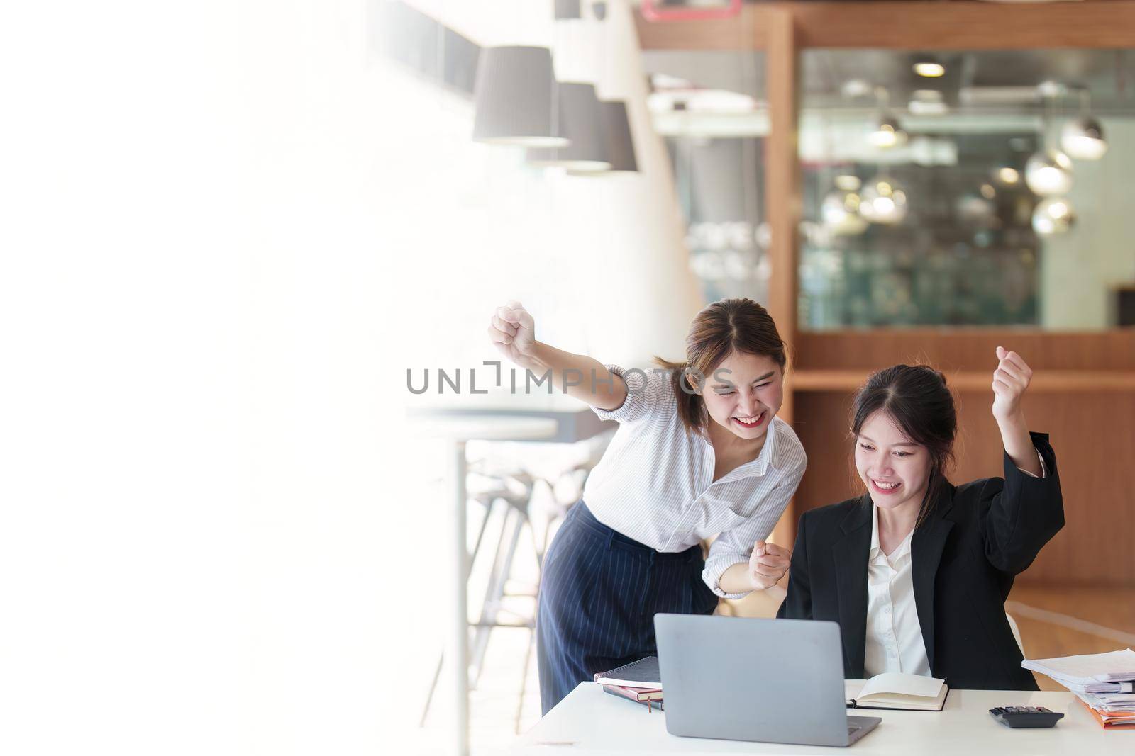 A portrait of two Asian business woman showing joy from sales of new projects that meet customer demand by Manastrong