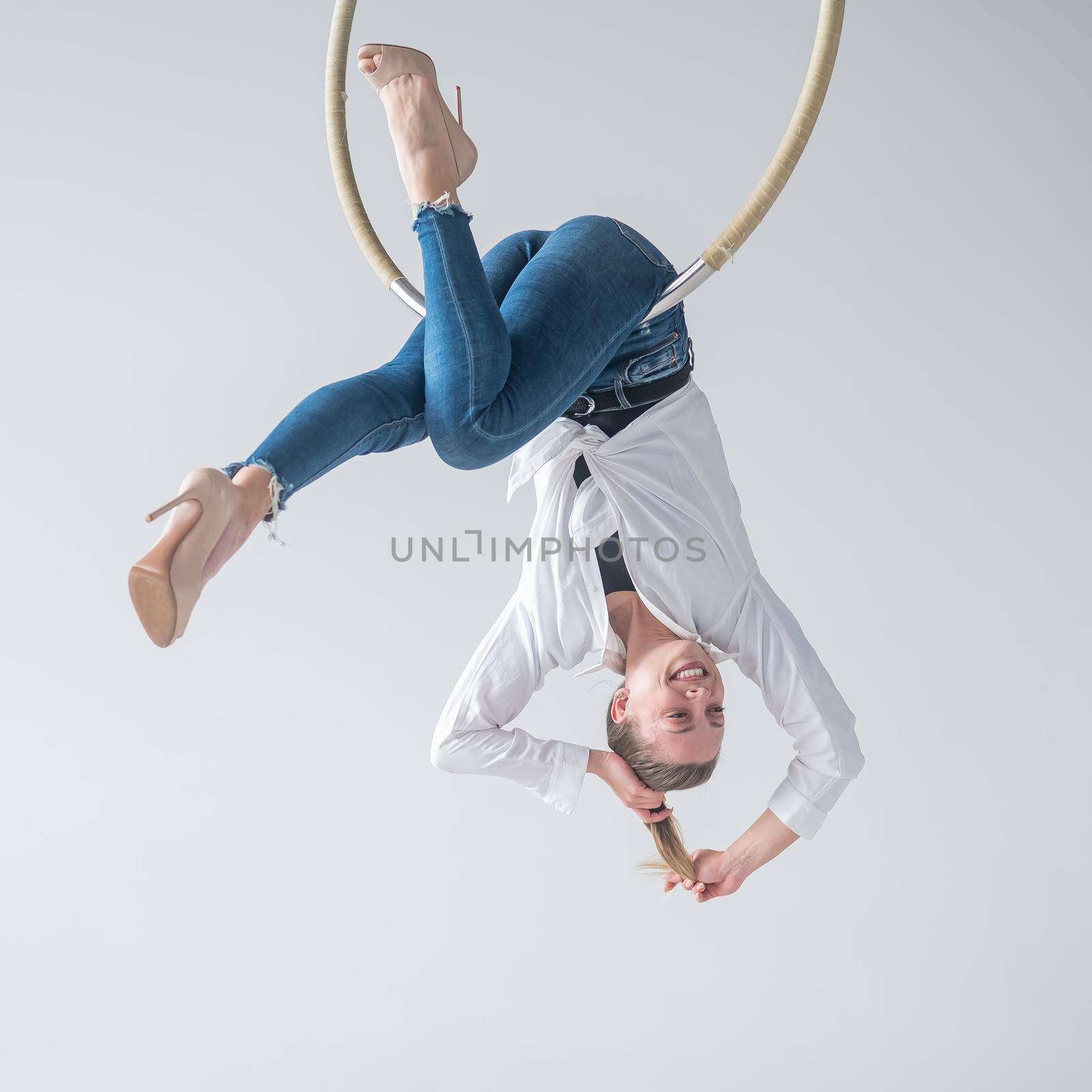 Caucasian woman in casual clothes on an aerial hoop. by mrwed54