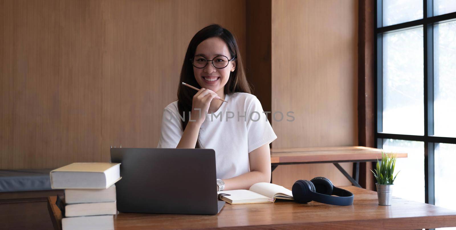 Smart asian young girl student feel satisfied during internet online courses and smile to you at home.