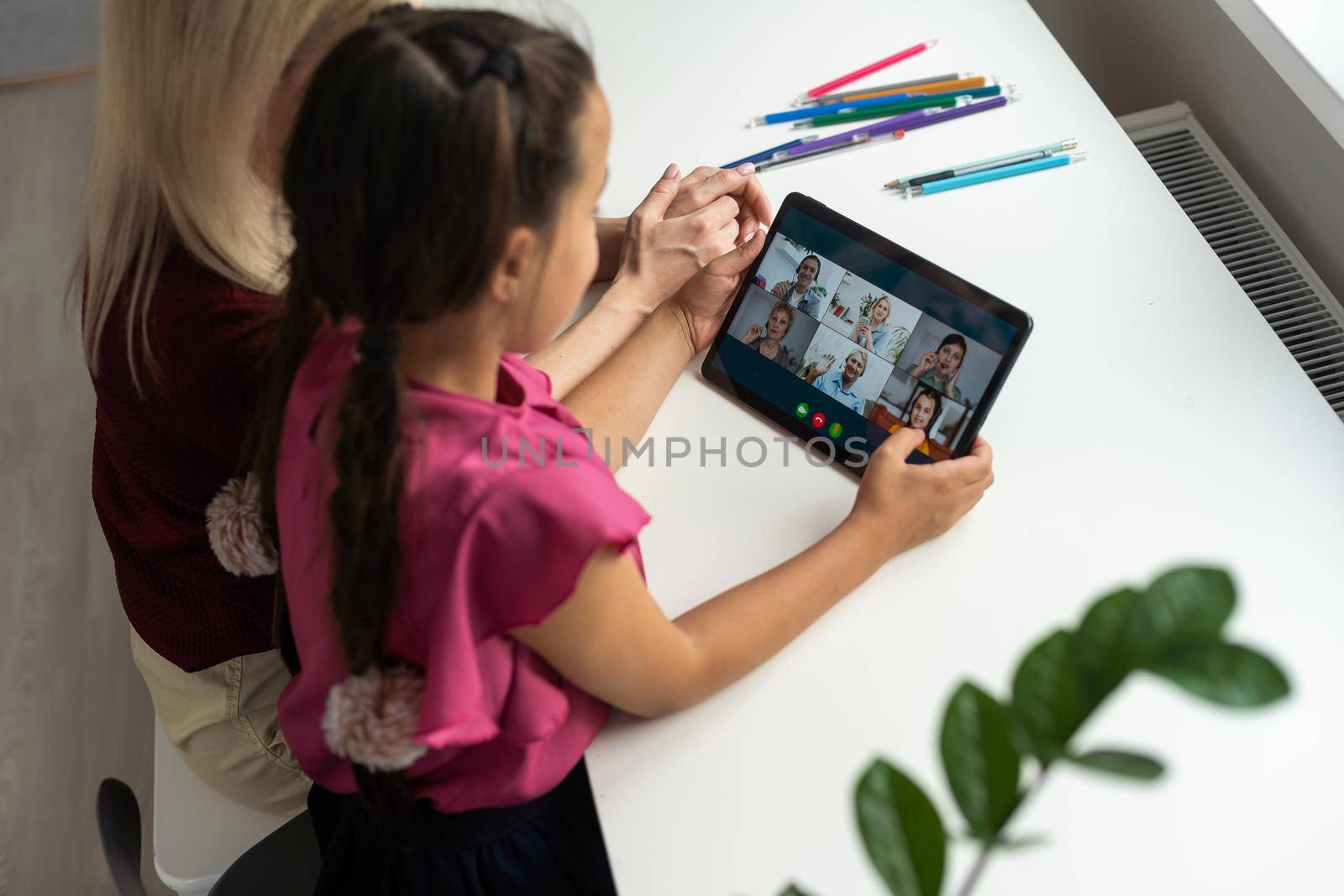 mother and daughter using digital tablet for online chatting from home by Andelov13