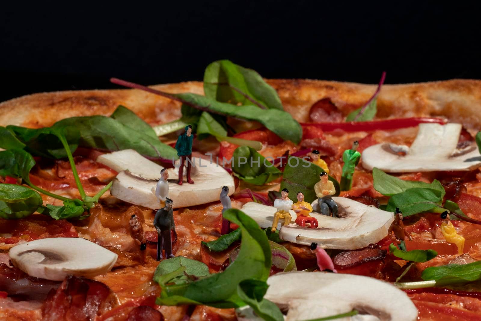 delicious pizza with fresh herbs close-up on a black background.