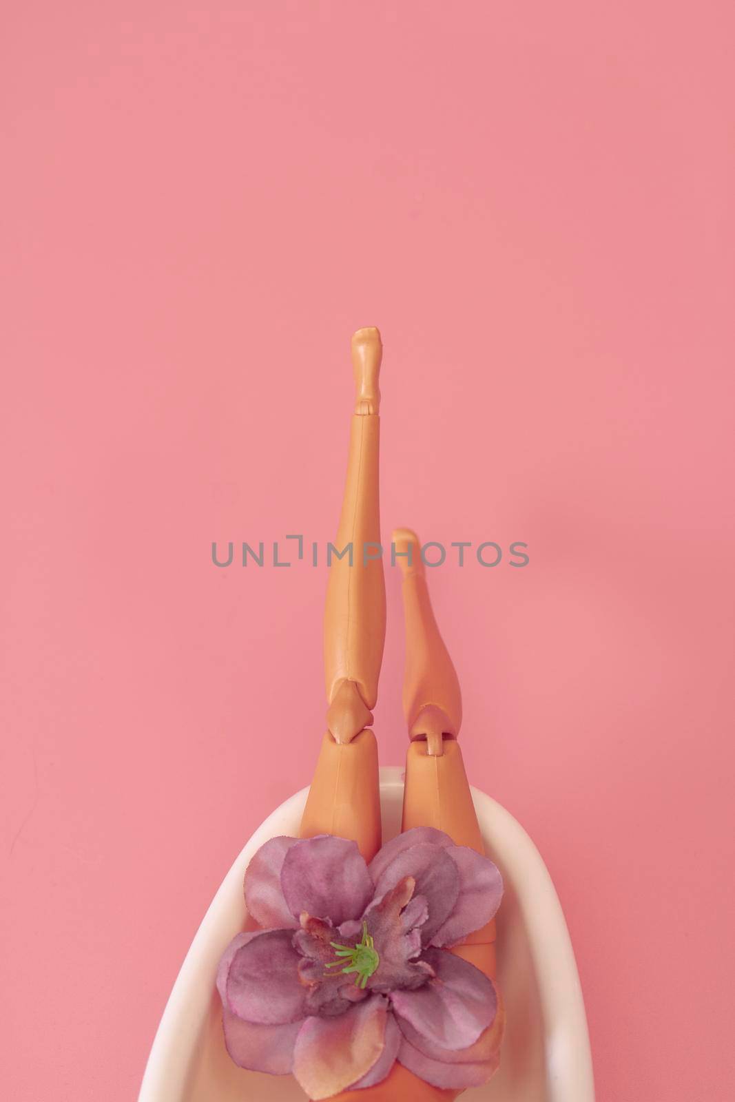 Doll bathing in a full bathtub on a pink background. Creative minimal beauty summer concept. Side view by Hitachin