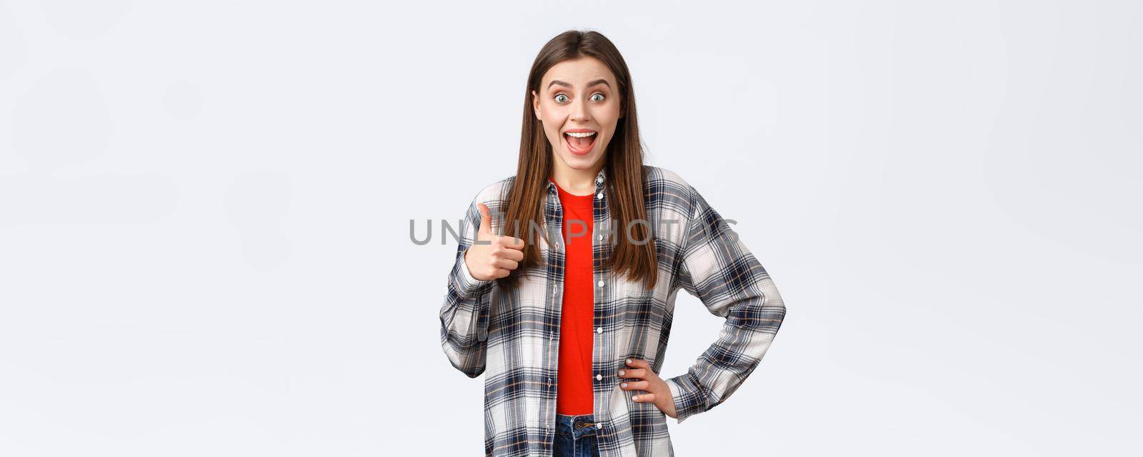 Lifestyle, different emotions, leisure activities concept. Surprised and excited cheerful girl support great idea, show thumb-up and smiling amazed, approva and like plan, white background.