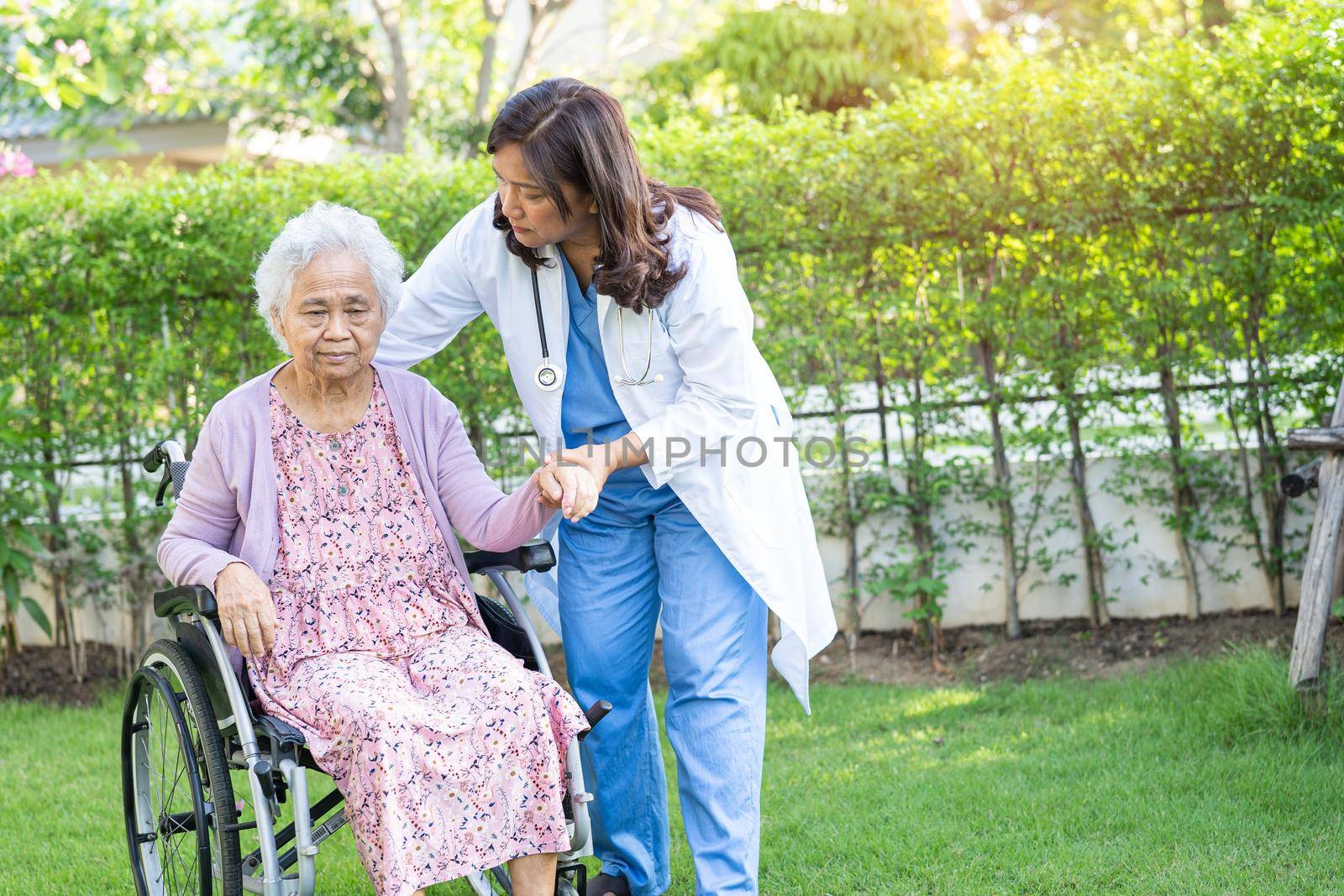 Doctor help and care Asian senior or elderly old lady woman patient sitting on wheelchair at park in nursing hospital ward, healthy strong medical concept. by pamai