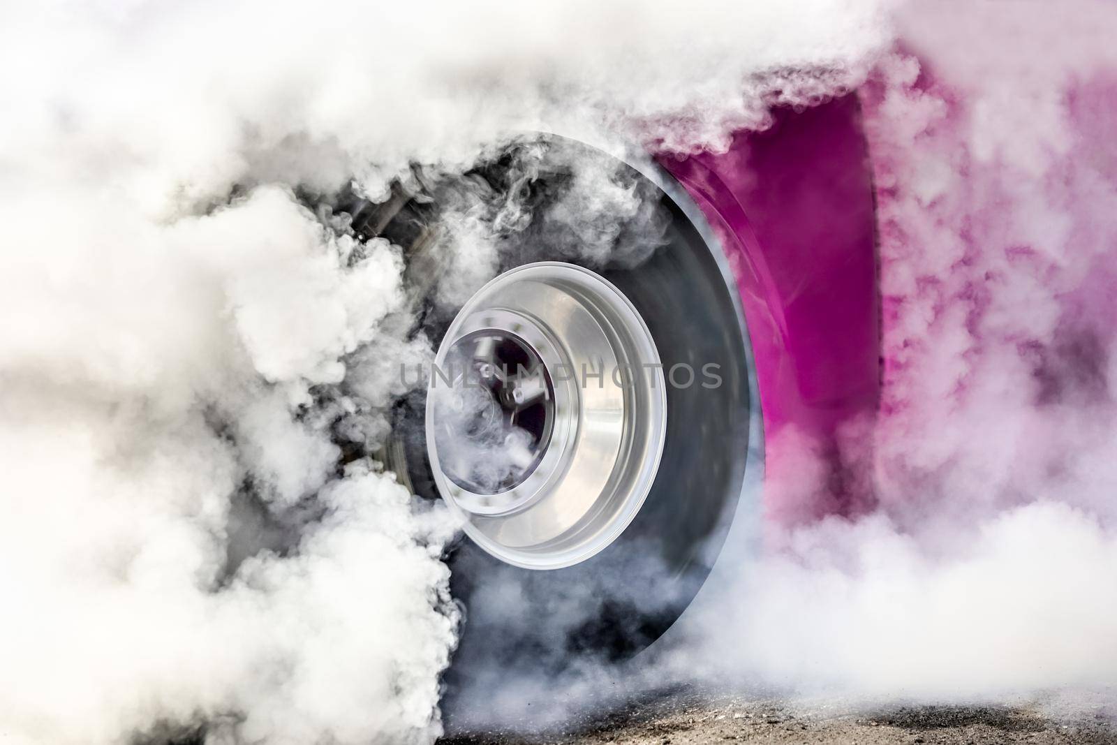 Drag racing car burns rubber off its tires in preparation for the race