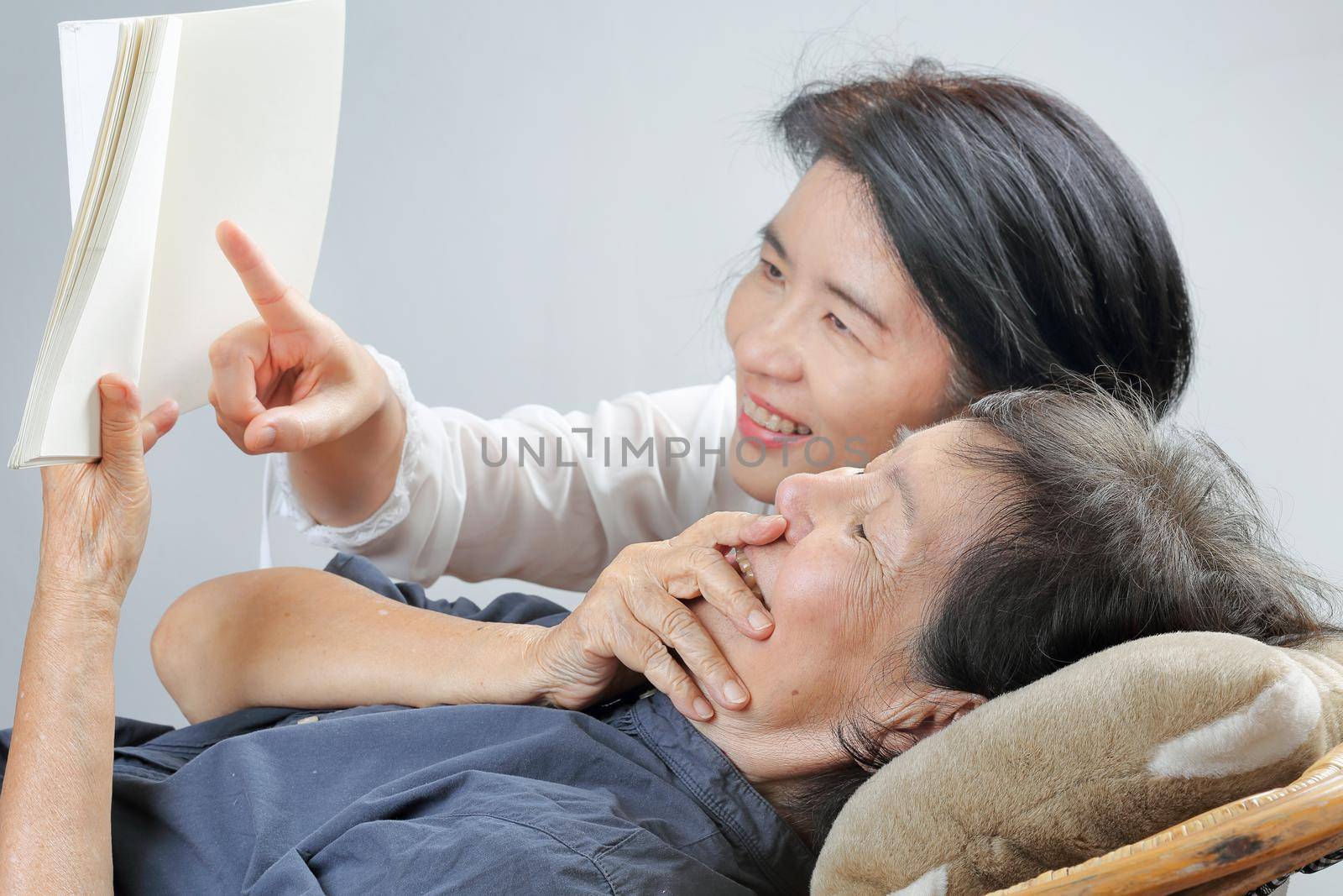 elderly woman reading fable book with daughter by toa55