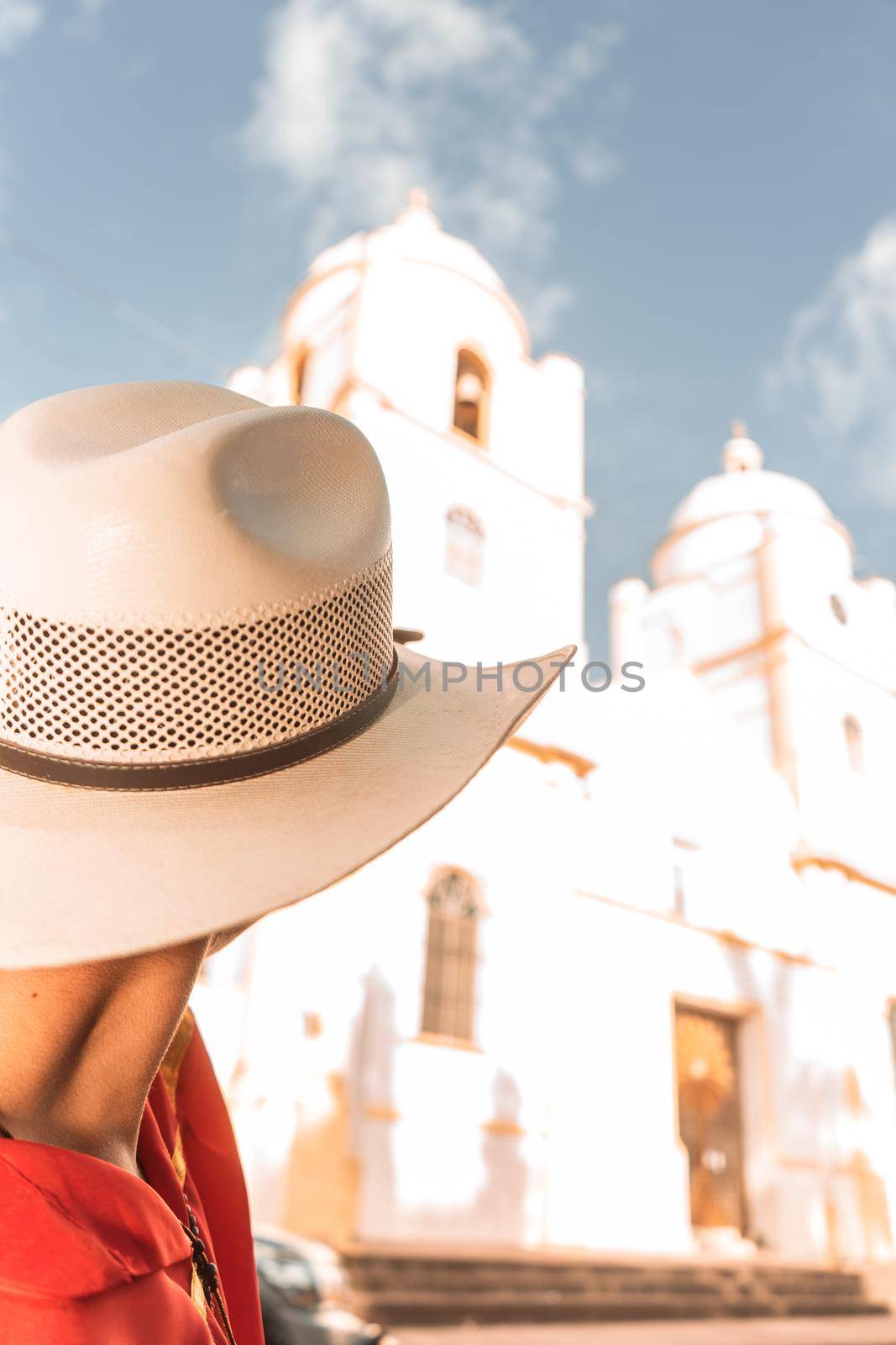 Young Nicaraguan man with hat looking towards the cathedral church in Jinotega, Nicaragua