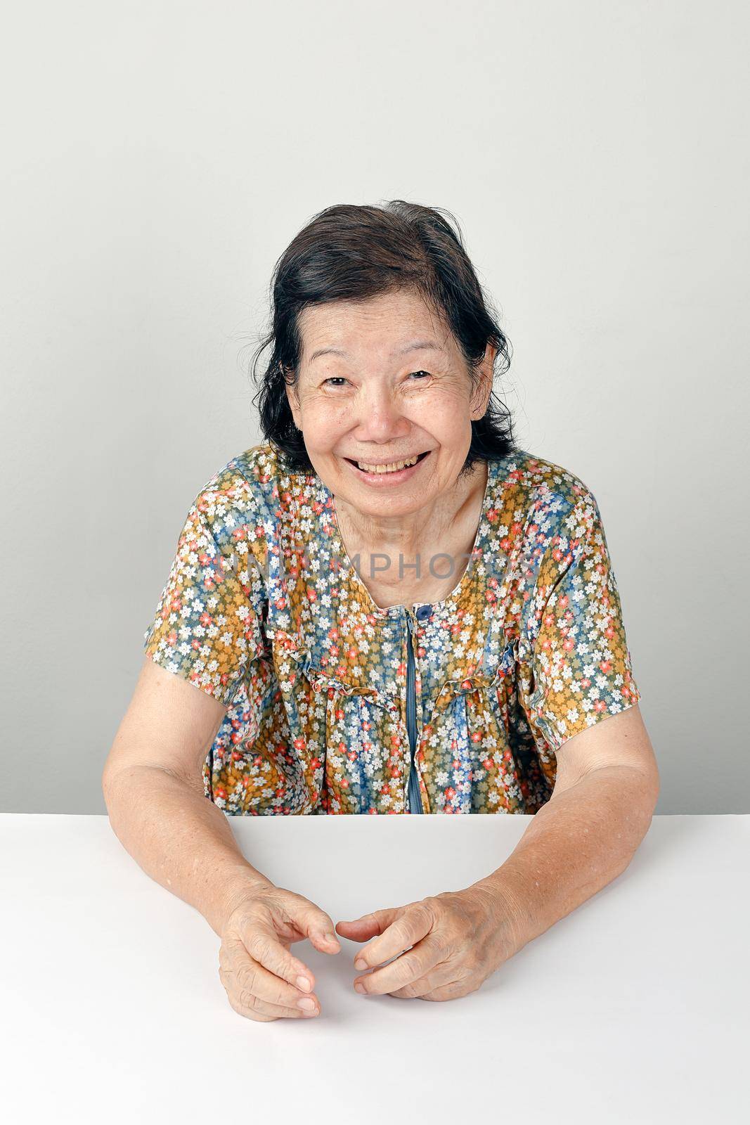 smiling elderly woman ,sitting on white background