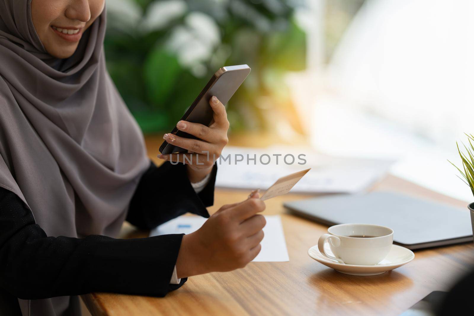 Close up hand of Muslim Woman wear hijab using online payment and holding credit card. Online Shopping concept