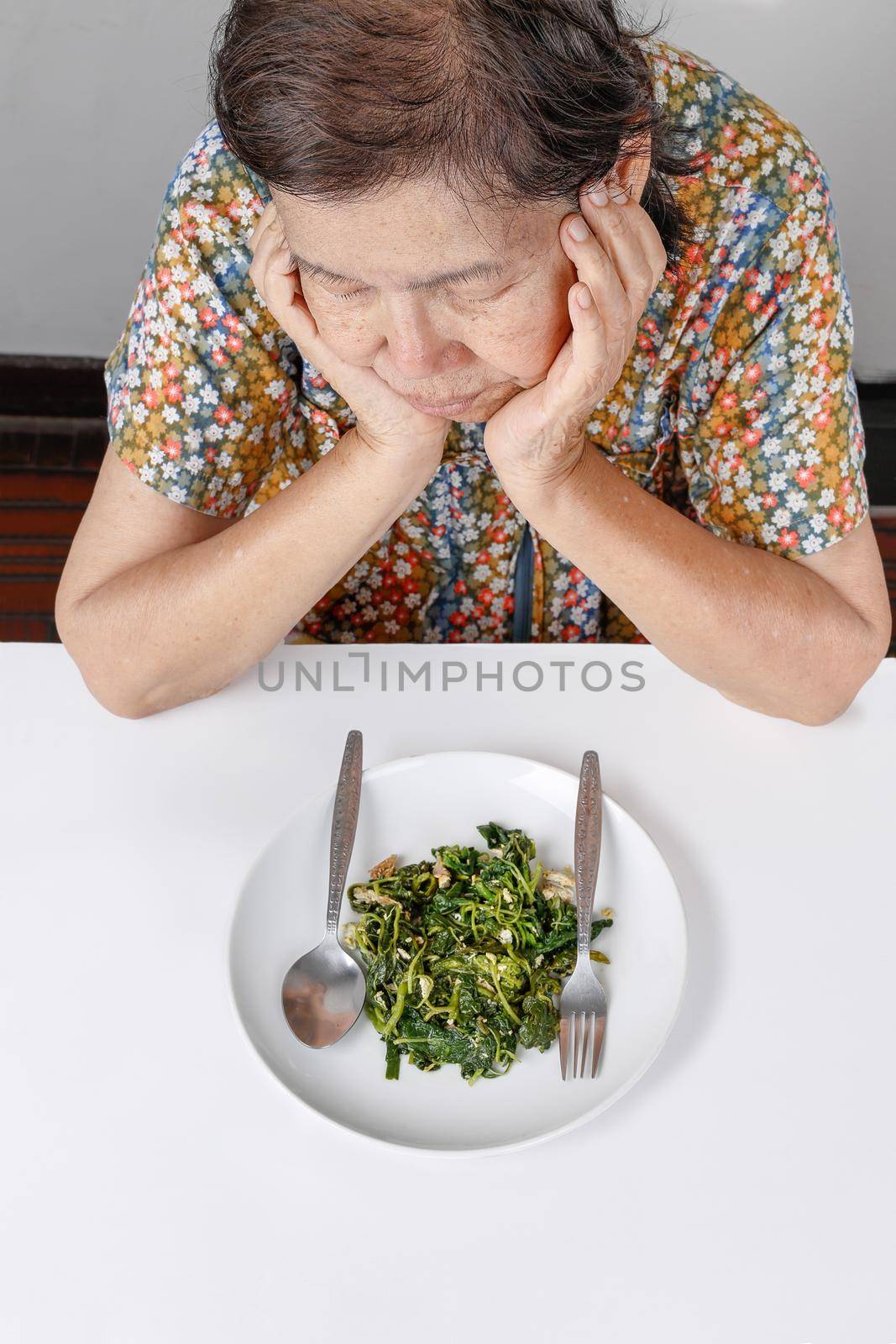 Elderly asian woman bored with food by toa55
