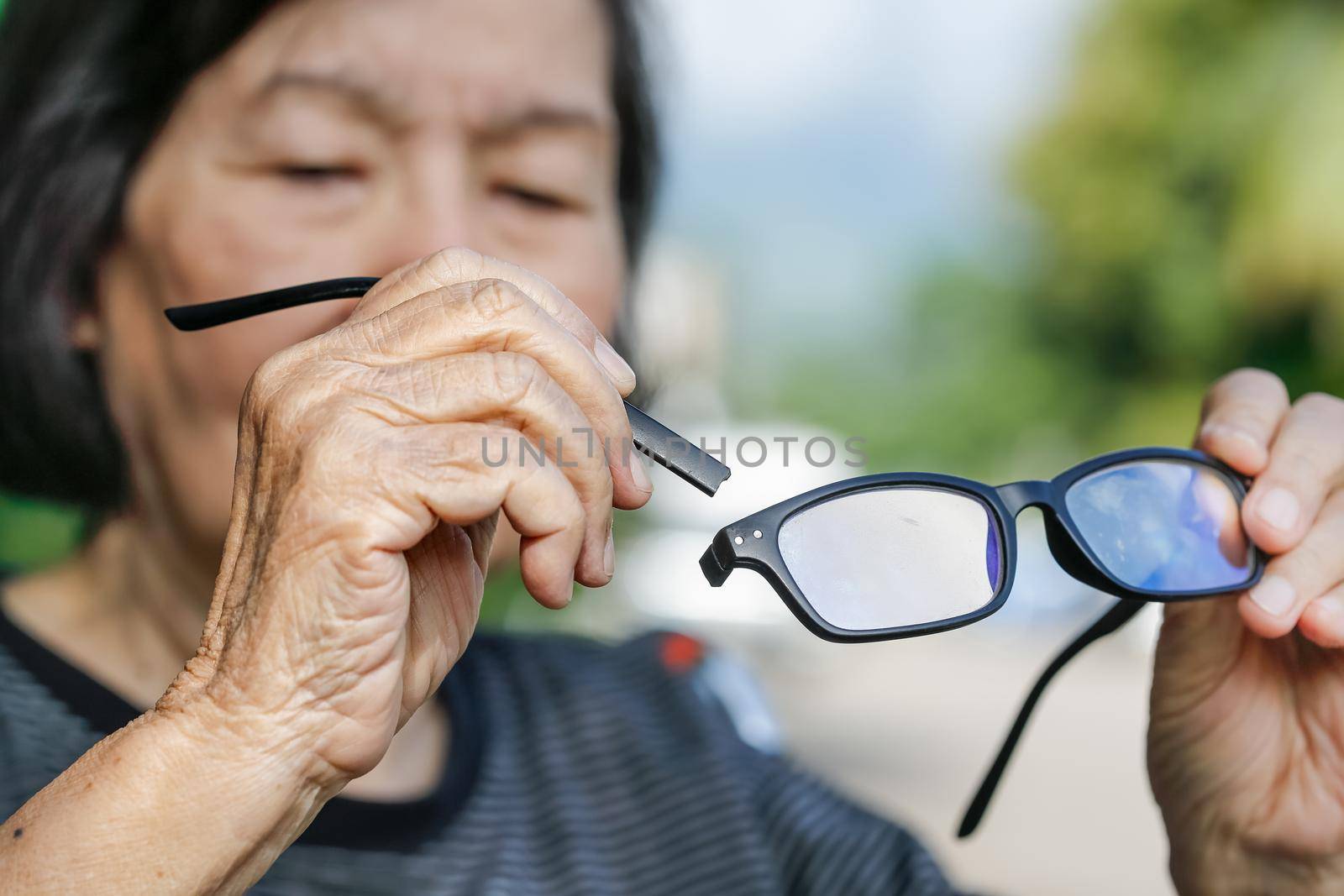 Elderly asian woman repair broken glasses