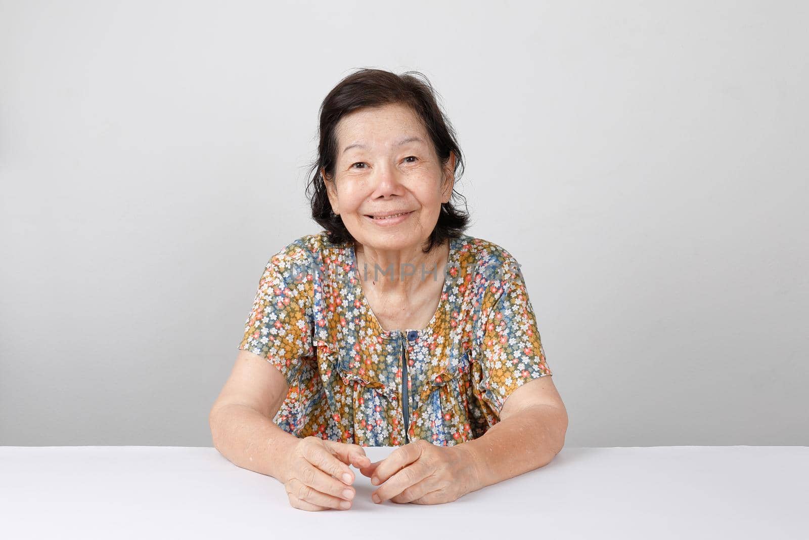 smiling elderly woman ,sitting on white background