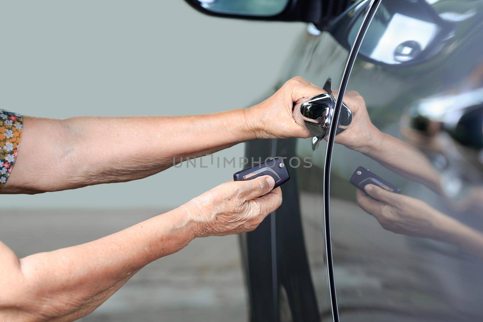 Elderly woman hand open the car on key car alarm systems