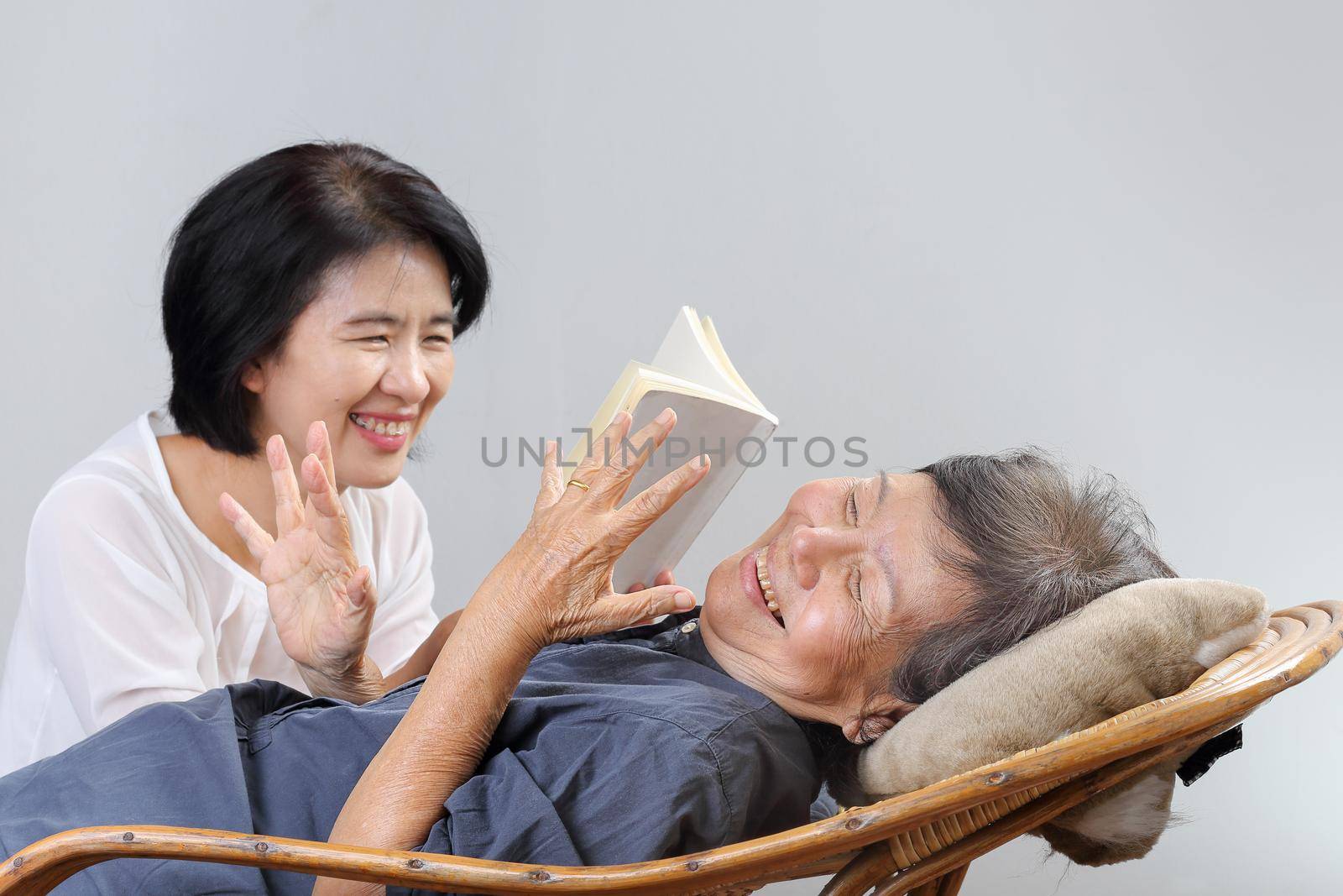 elderly woman reading fable book with daughter by toa55
