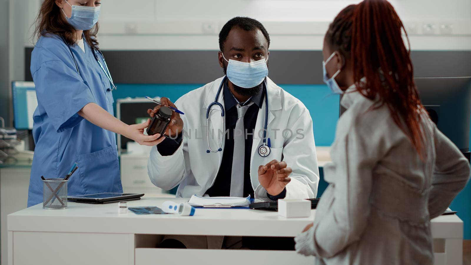 General practitioner giving bottle of pills as prescription treatment by DCStudio