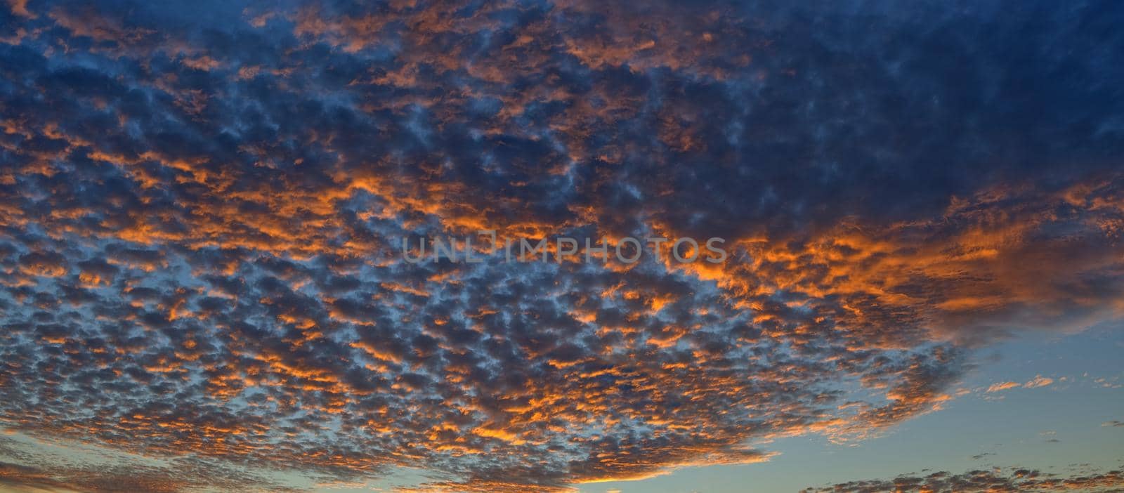 Scenic panoramic view of colorful sunset and cloudscape, dramatic panorama evening sky after sunset