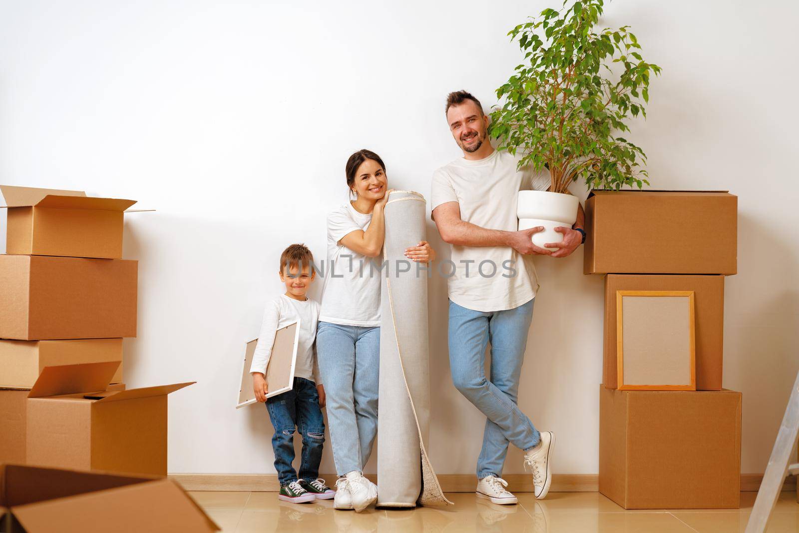 Portrait of happy family with cardboard boxes in new house at moving day, close up