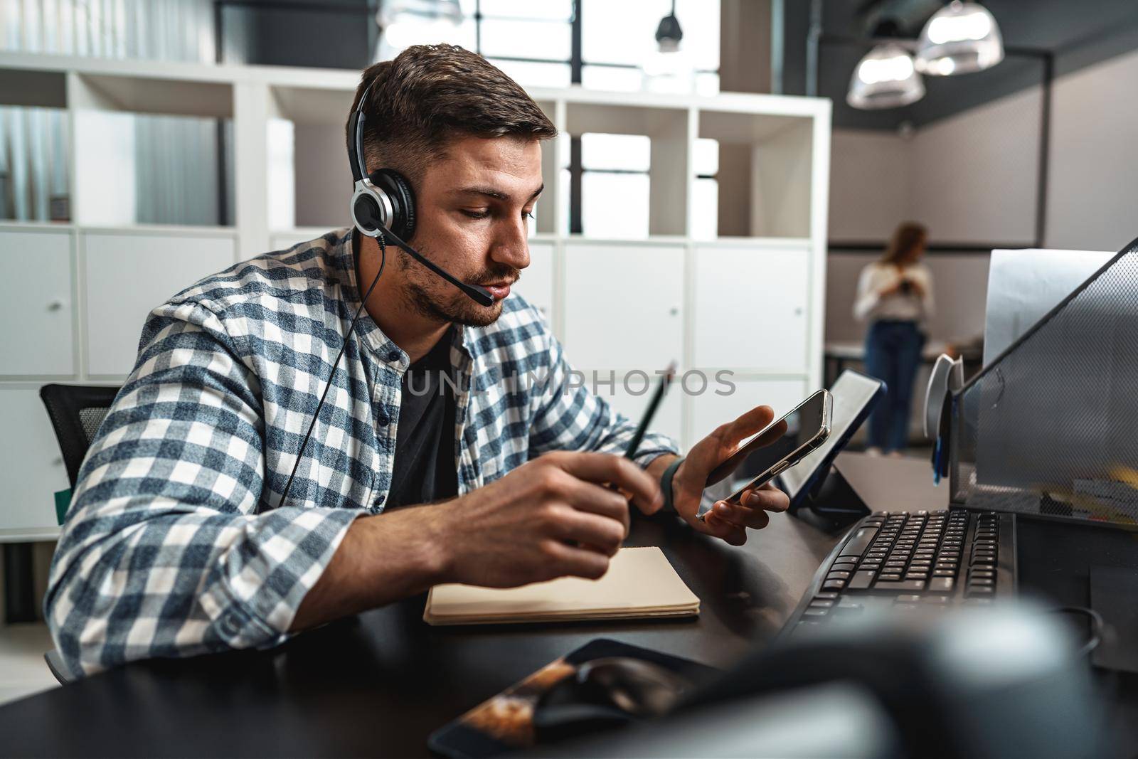 Customer service support operator man with headphones and microphone talking to client in call center by Fabrikasimf