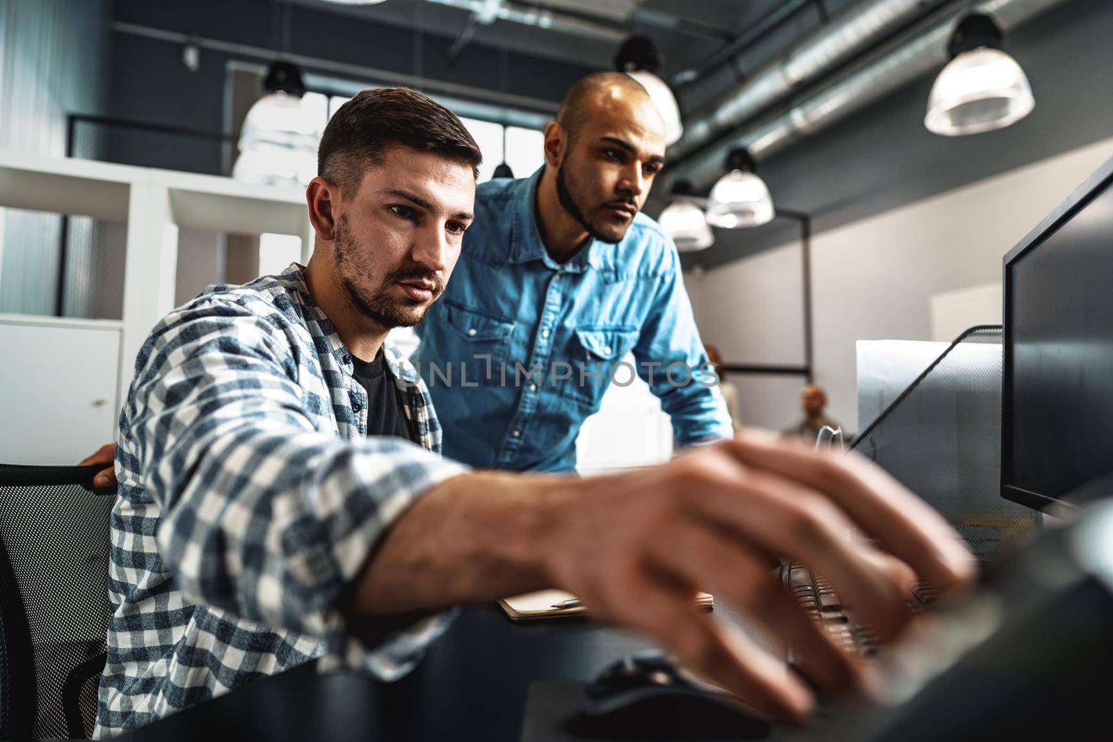 Two young men working together on a new business project in office, close up