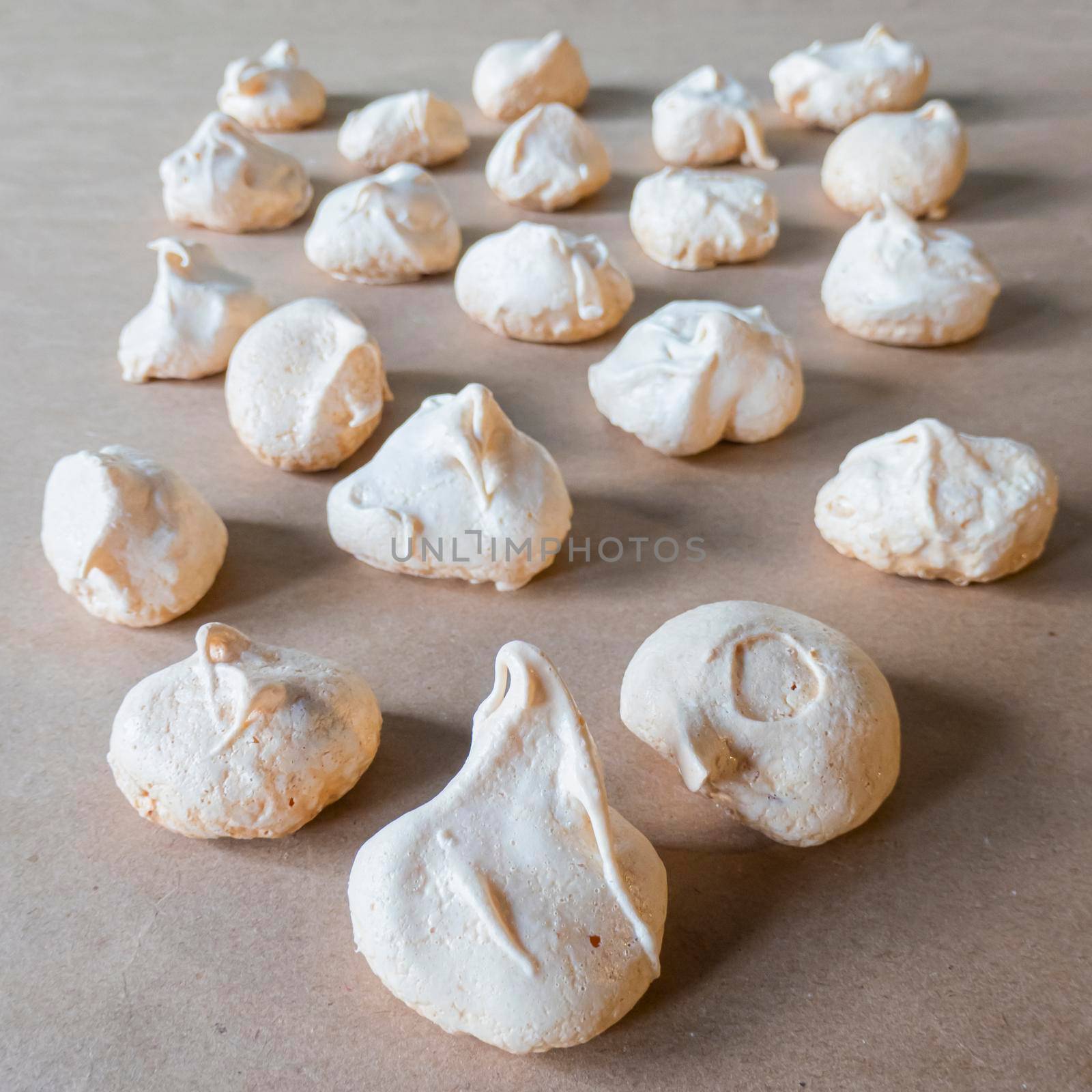 Homemade french milk-colored meringues on crumpled craft paper. flatley composition: delicious homemade meringues on craft paper