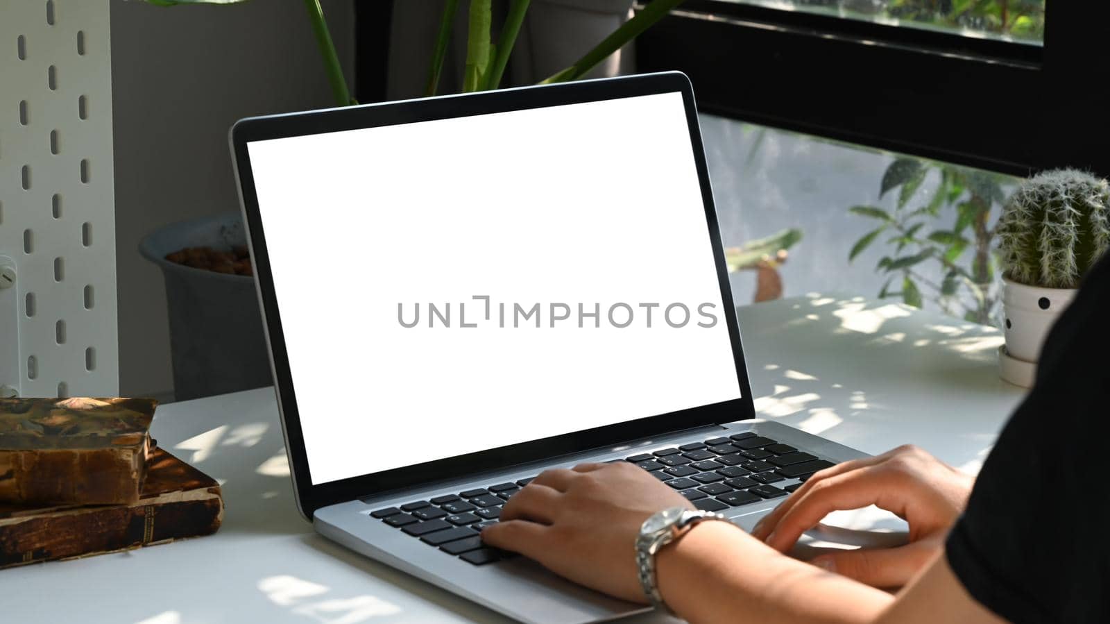 Close up view female freelancer sitting in modern home office and using laptop computer. by prathanchorruangsak