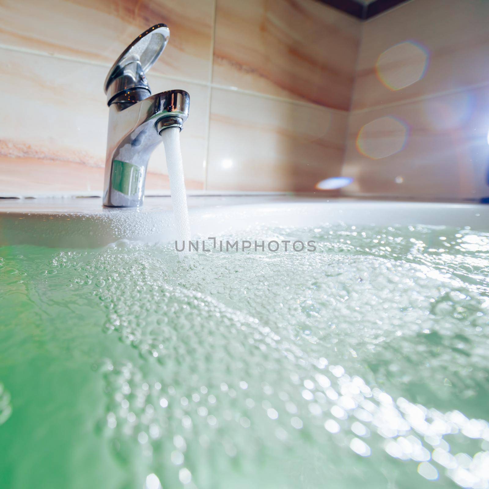 single handle faucet pouring hot water in a bath tub by nikkytok