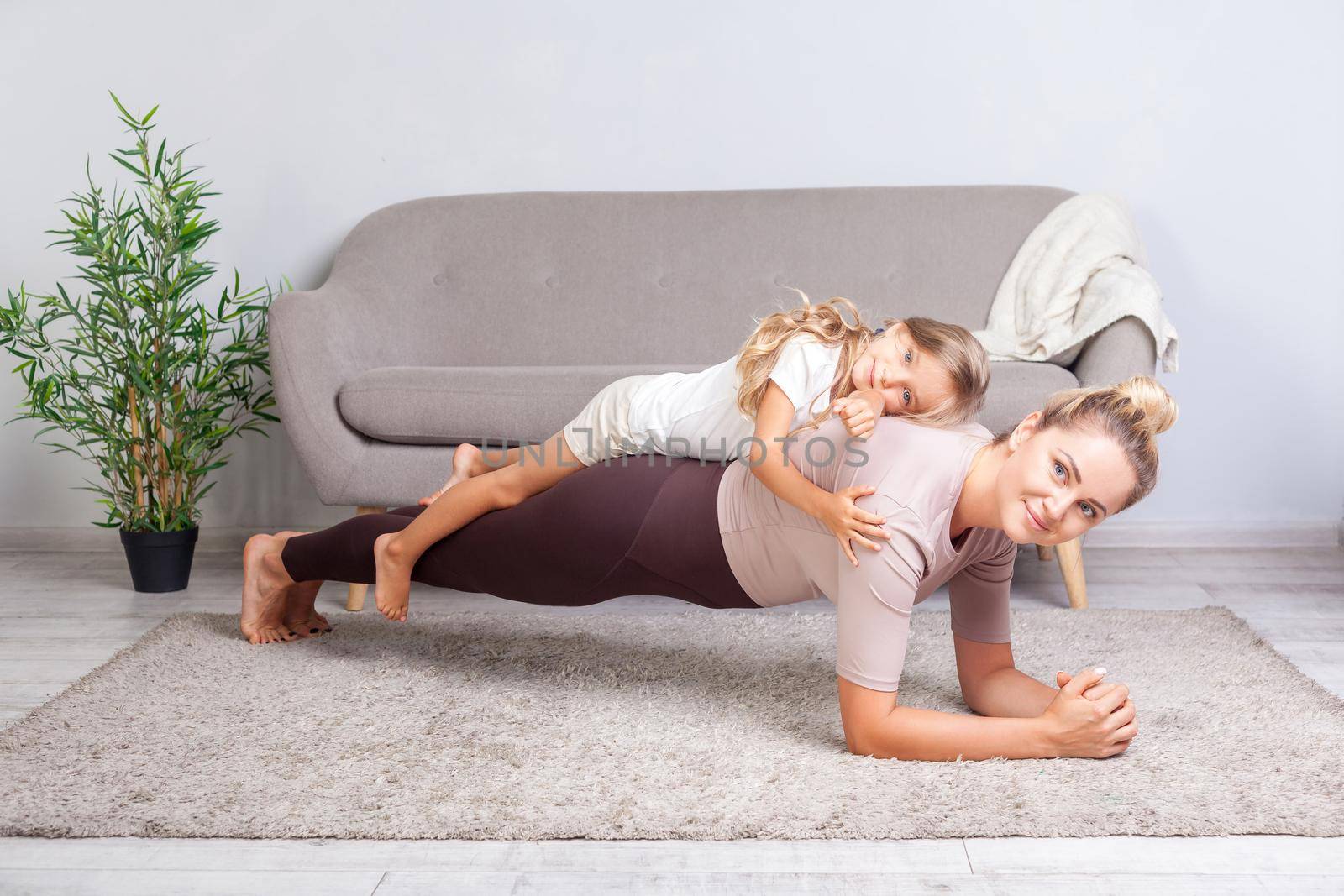 Mother and daughter exercising together and having fun at home by Khosro1