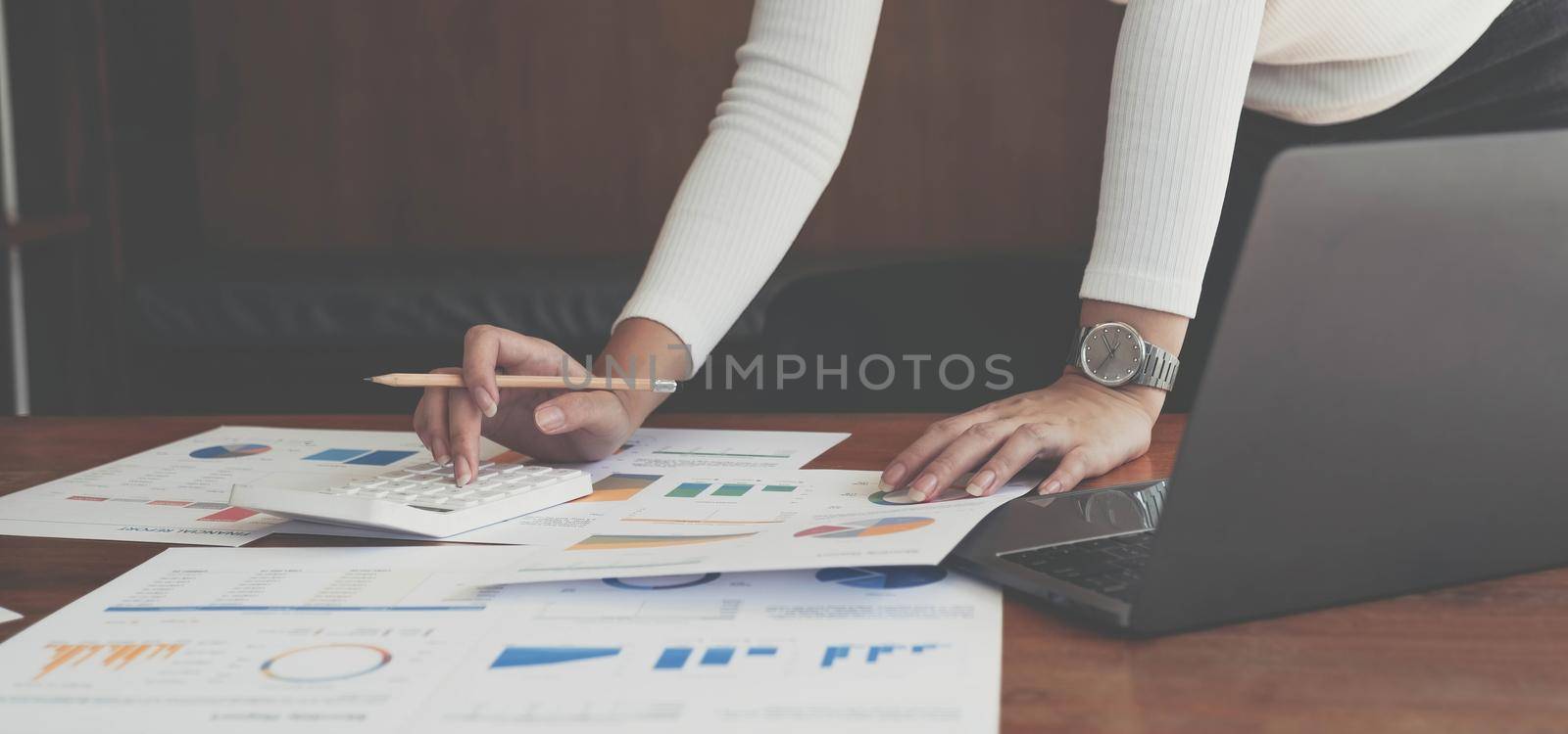 Businesswomen are calculating income-expenditure and analyzing real estate investment data, Accounting Financial and tax systems concept. by wichayada