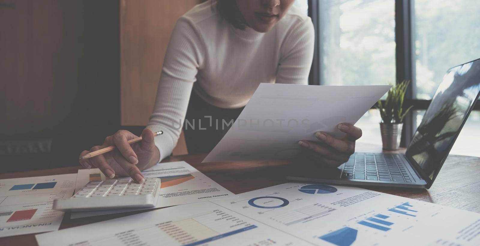 Closeup of female who are using their fingers to press the calculator for calculating bills in the office.finance report. Business office concept. by wichayada