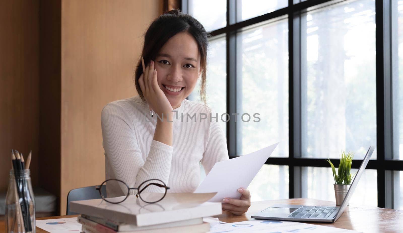 Portrait of smiling beautiful business asian woman with working in modern office desk using laptop computer, Business people employee freelance online marketing e-commerce telemarketing concept. by wichayada