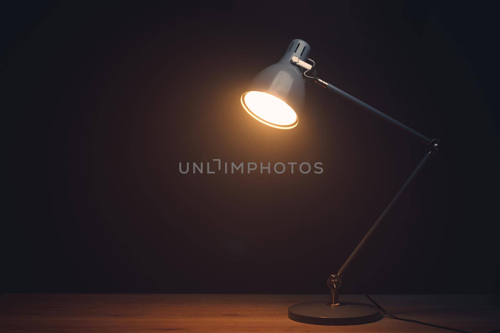 desk lamp in mist, black background with copy-space