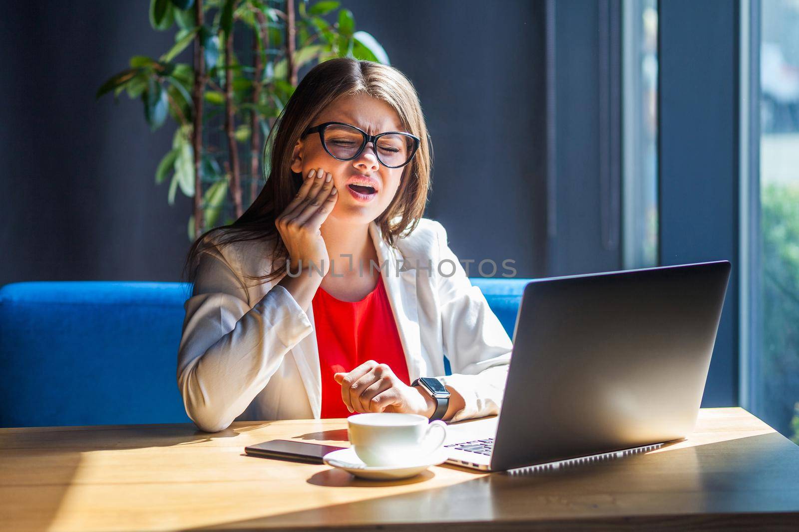 Emotional worker woman sitting in office with her laptop. by Khosro1