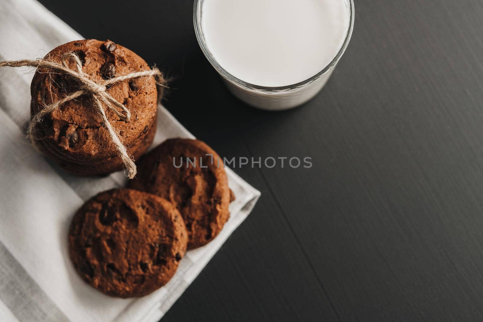 Flat Lay of Glass is Filled with Milk and Homemade Cookies on Black Table