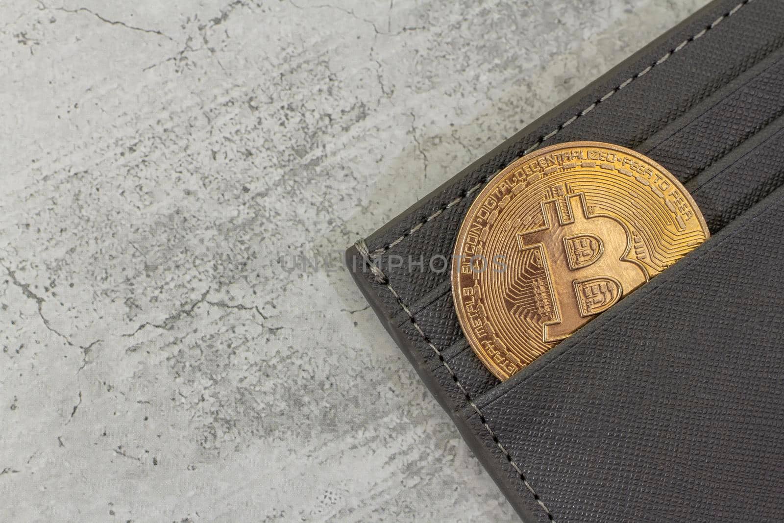 bitcoin gold coin place in wallet on concrete background. Online payment technology, digital wallet, computer financial, digital blockchain, bitcoin stock, cryptocurrency trading and mining investment concept.