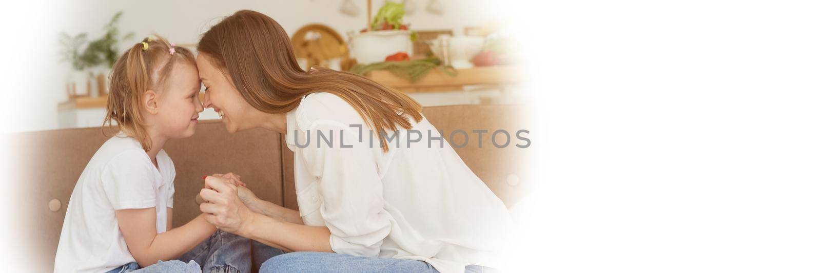 The trusting relationship of mom and daughter. Conversation of a woman with a little girl at home on the couch in the kitchen. Web banner