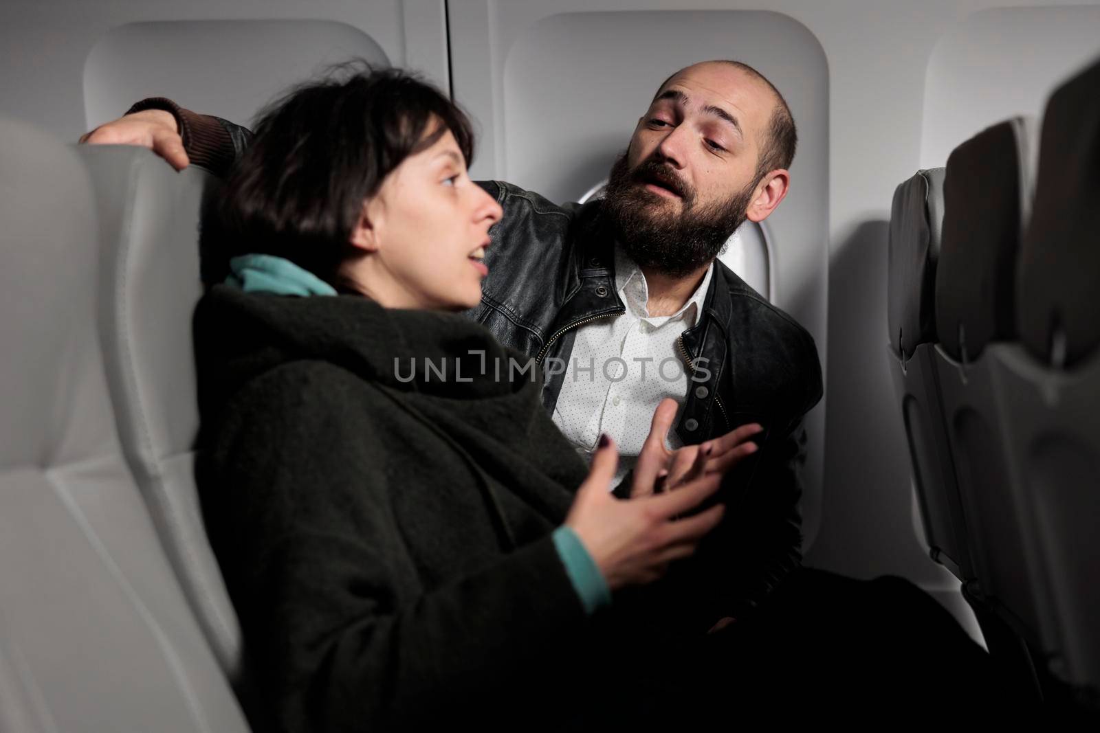 Jet passengers having conversation on commercial flight by DCStudio