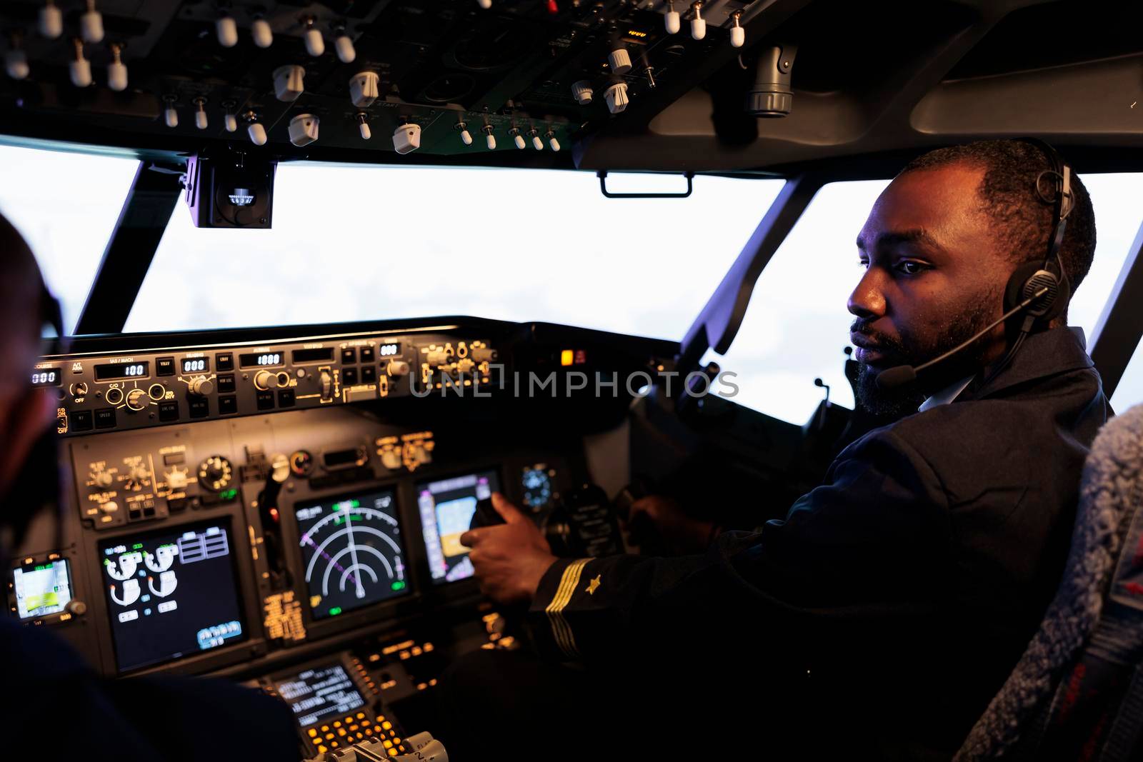 African american aviator flying plane jet in teamwork with captain, using dashboard command and navigation. Team of airliners pushing control panel buttons and lever to takeoff and fly.