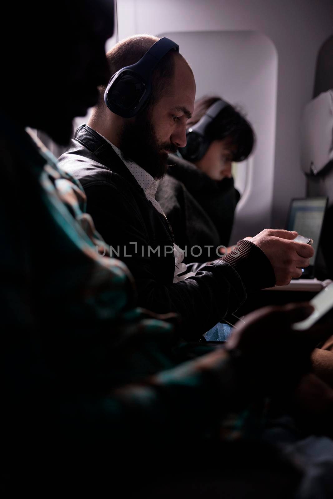 Group of tourists travelling on airplane and using laptop by DCStudio