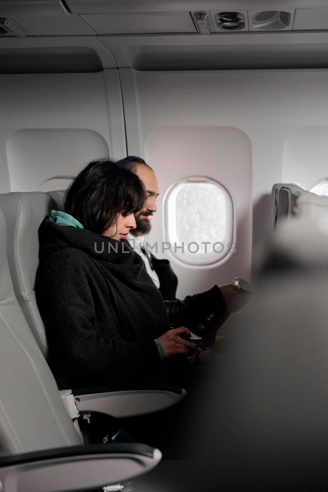 Woman tourist fastening seatbelt before takeoff on airplane flight, buckle up belt to prepare for departure. Flying in economy class and travelling by plane to leave on vacation journey.