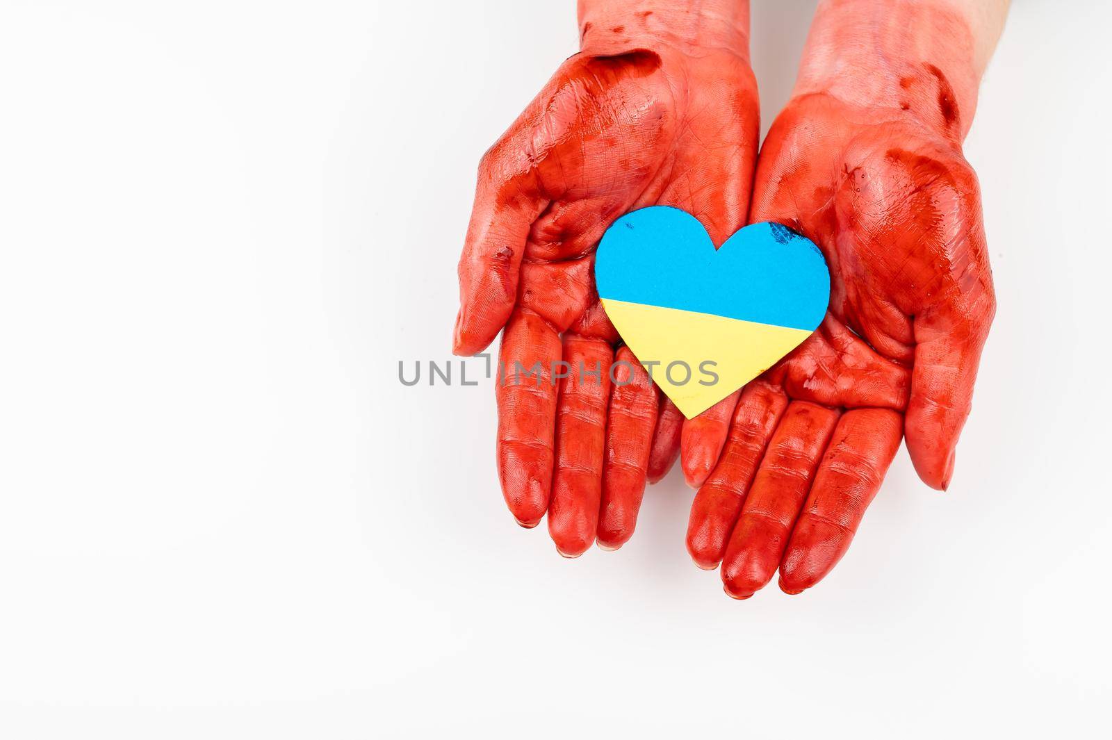 Woman with hands covered in blood holding a heart with the flag of ukraine on a white background