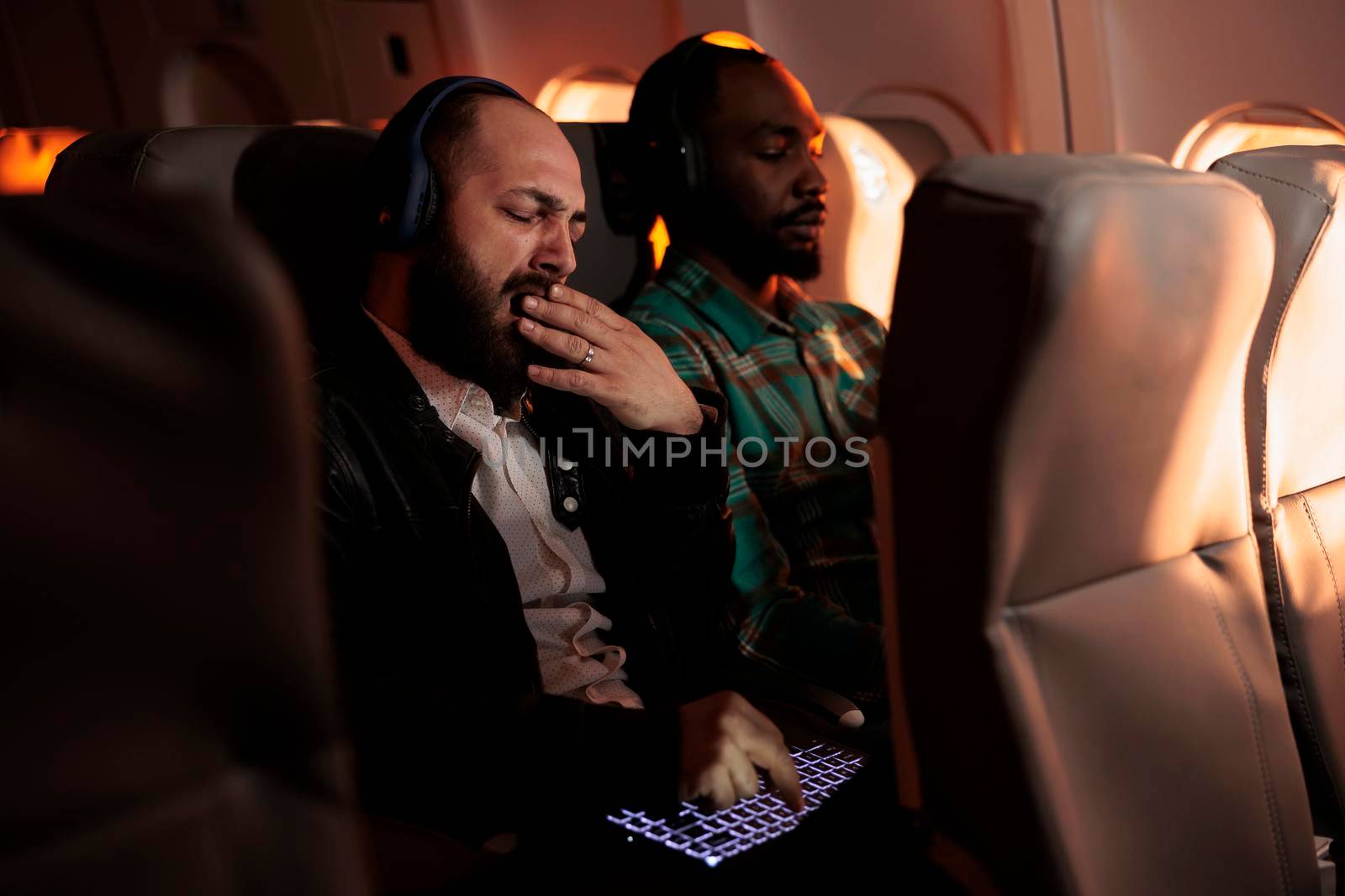 Diverse people sitting in airplane on commercial flight by DCStudio