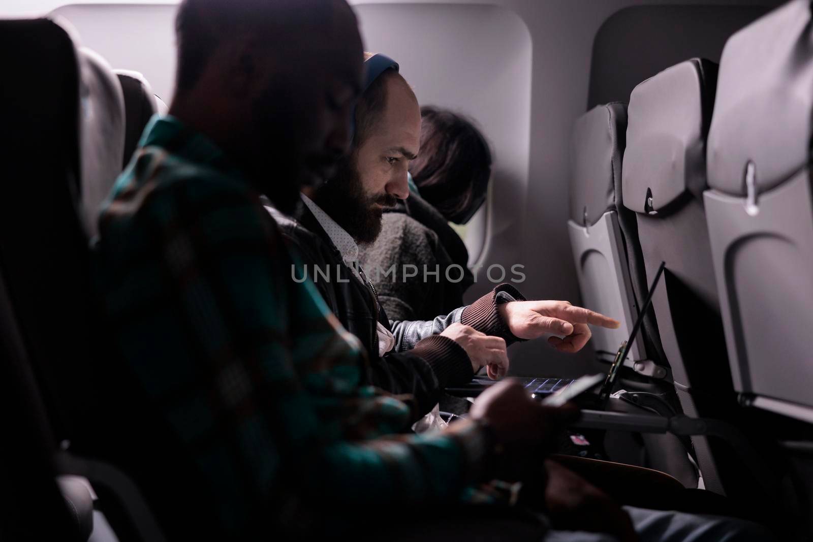 Sitting passengers flying in economy class with airplane by DCStudio