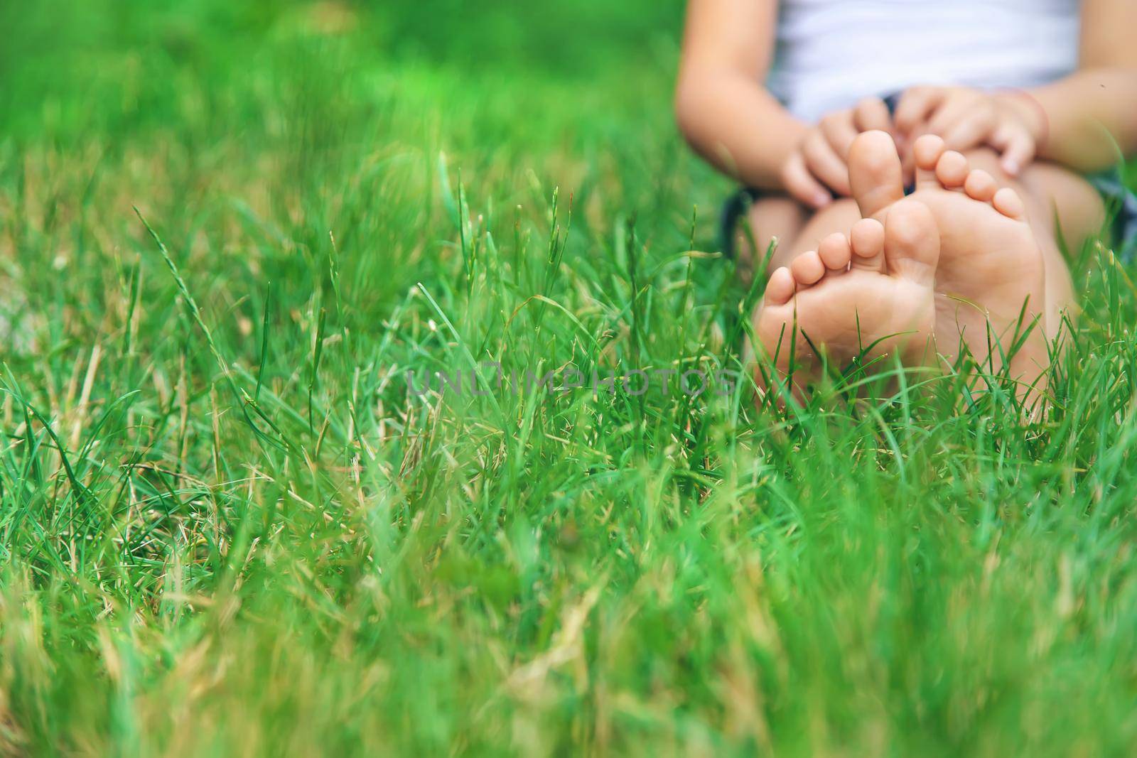 Children's feet on the green grass in the park. Selective focus. nature.