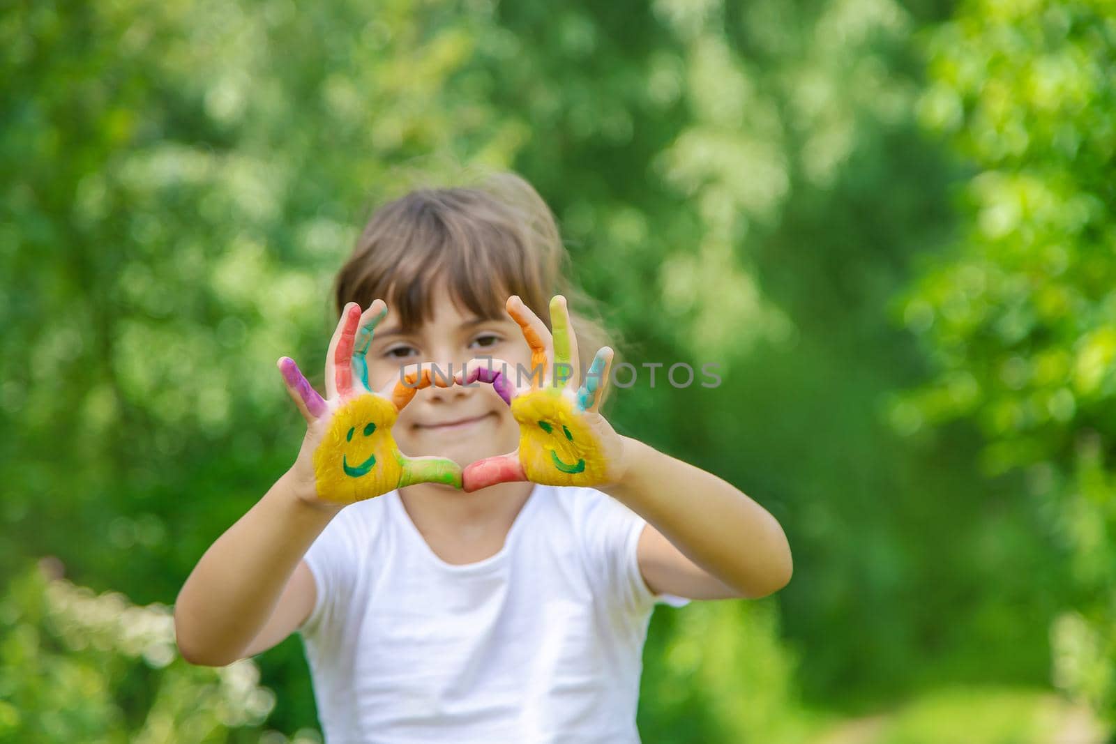 Child hands in paints a smile. Selective focus.