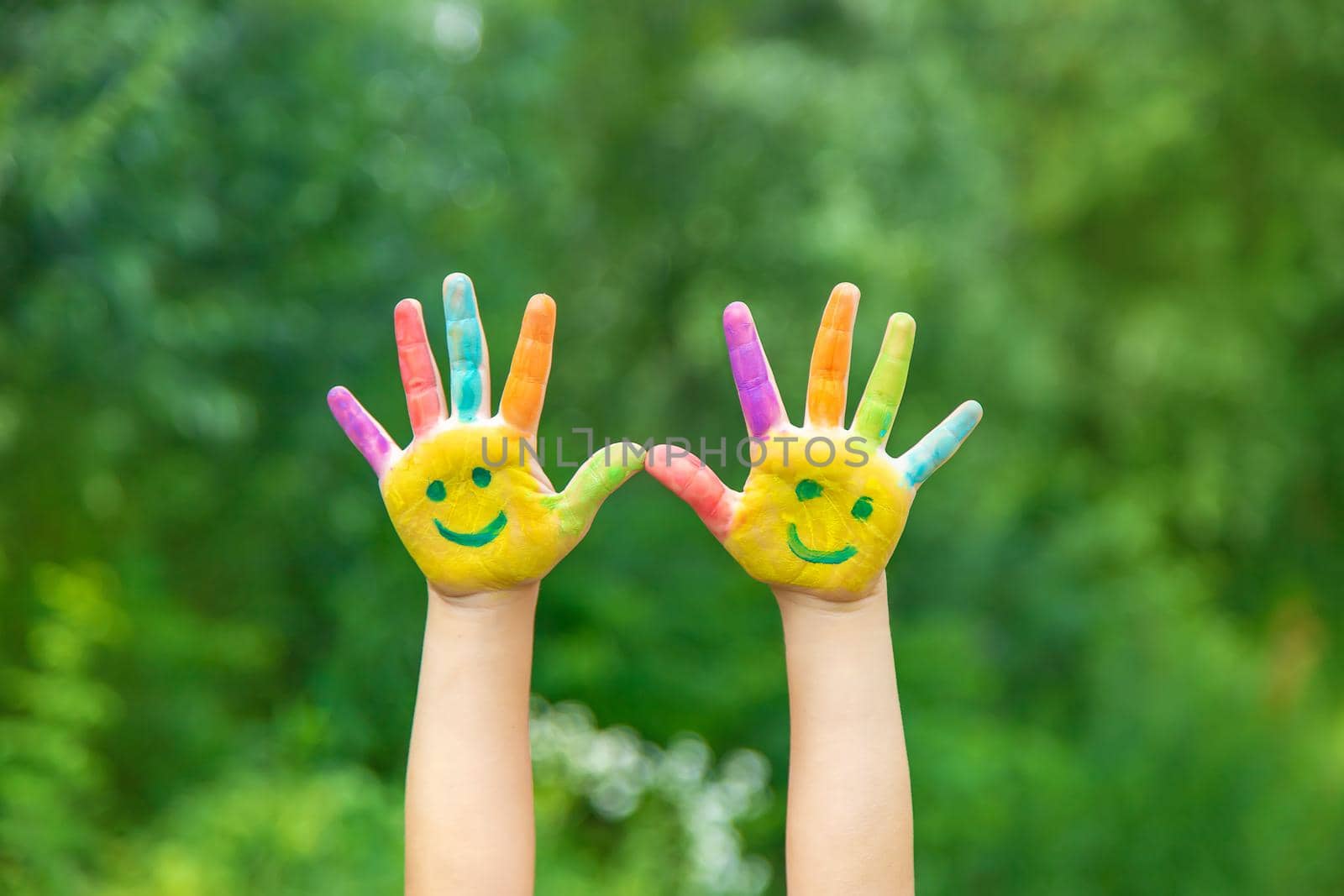 Child hands in paints a smile. Selective focus. by yanadjana