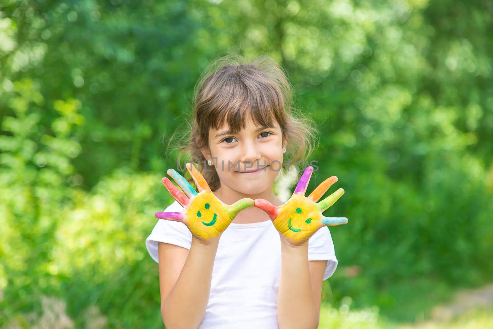 Child hands in paints a smile. Selective focus. by yanadjana