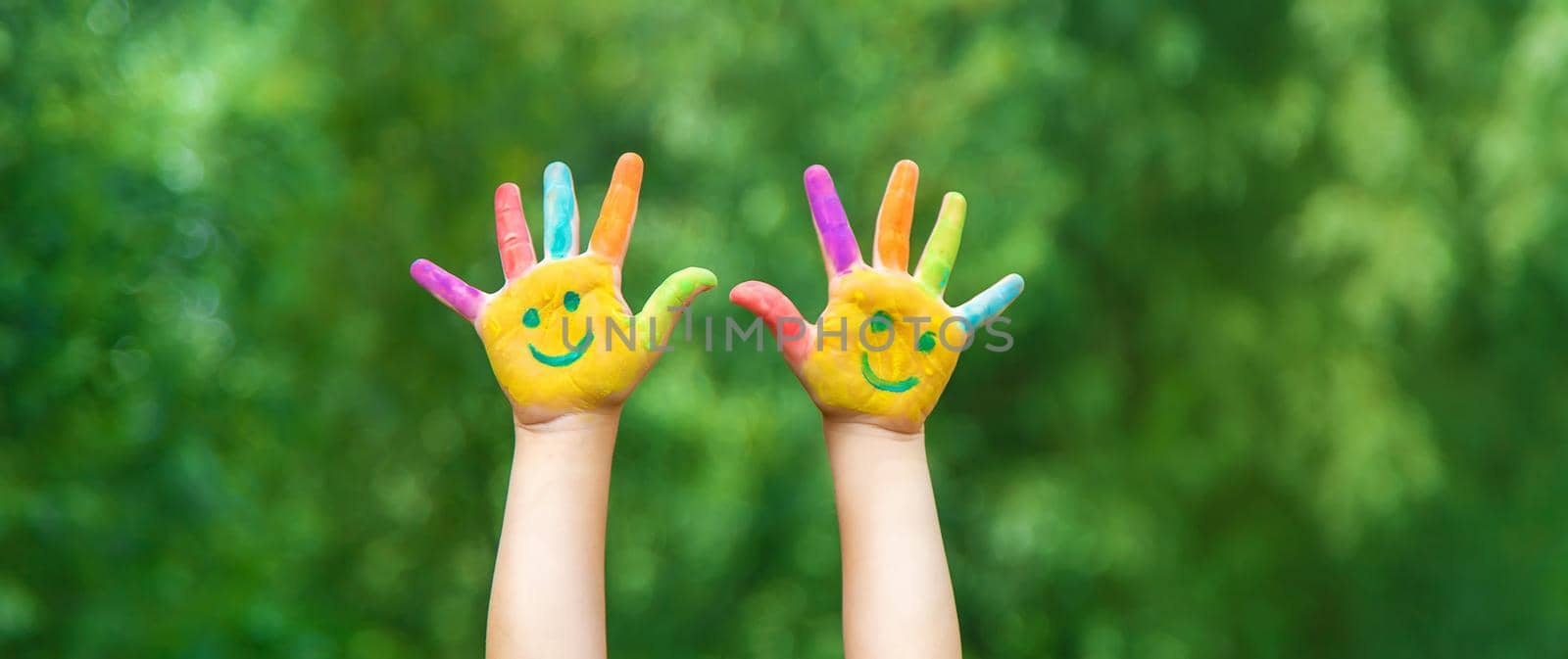 Child hands in paints a smile. Selective focus. nature.