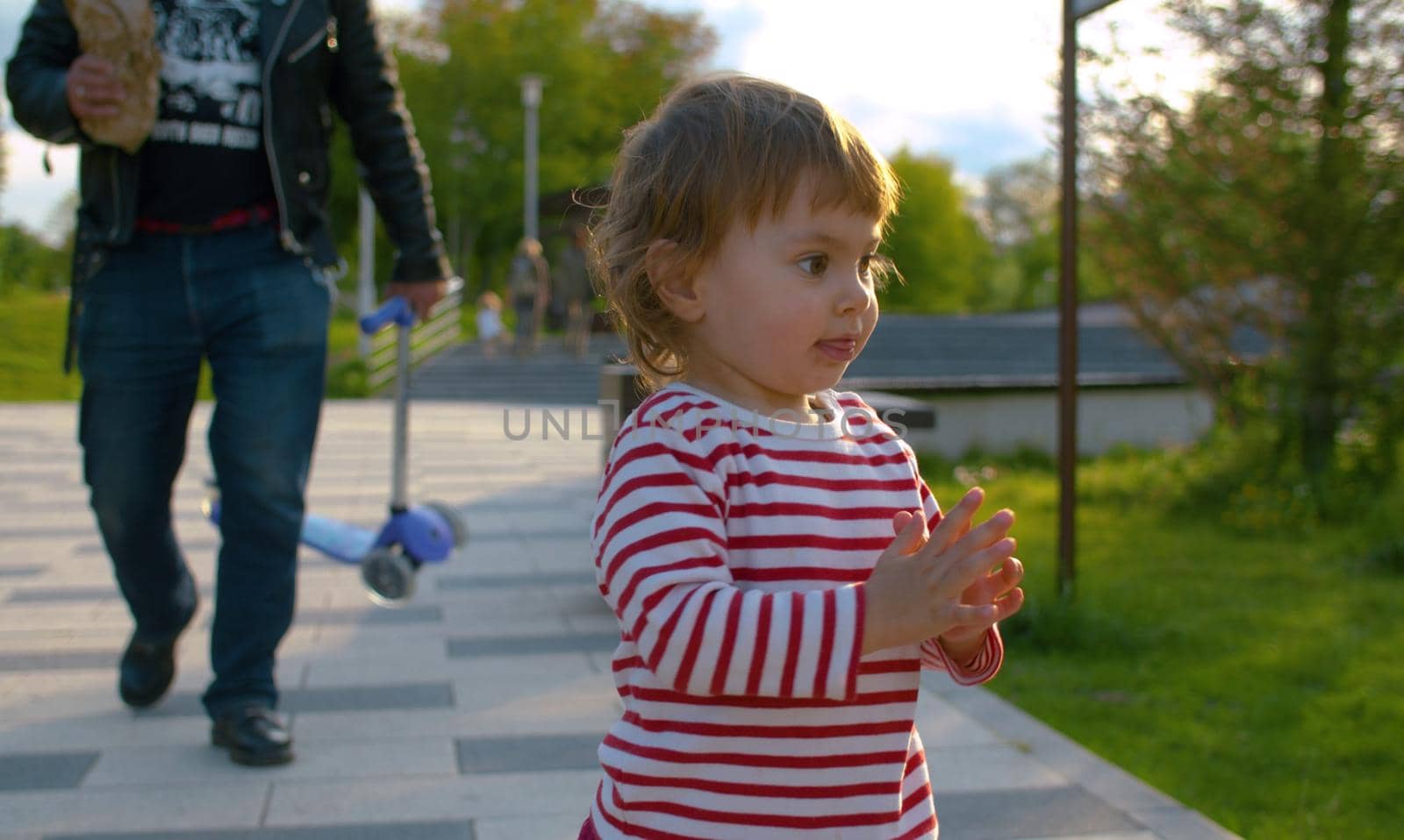 Little baby girl is walking in the park