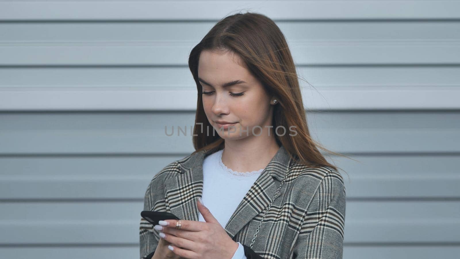 A student girl in a blazer talking on the phone