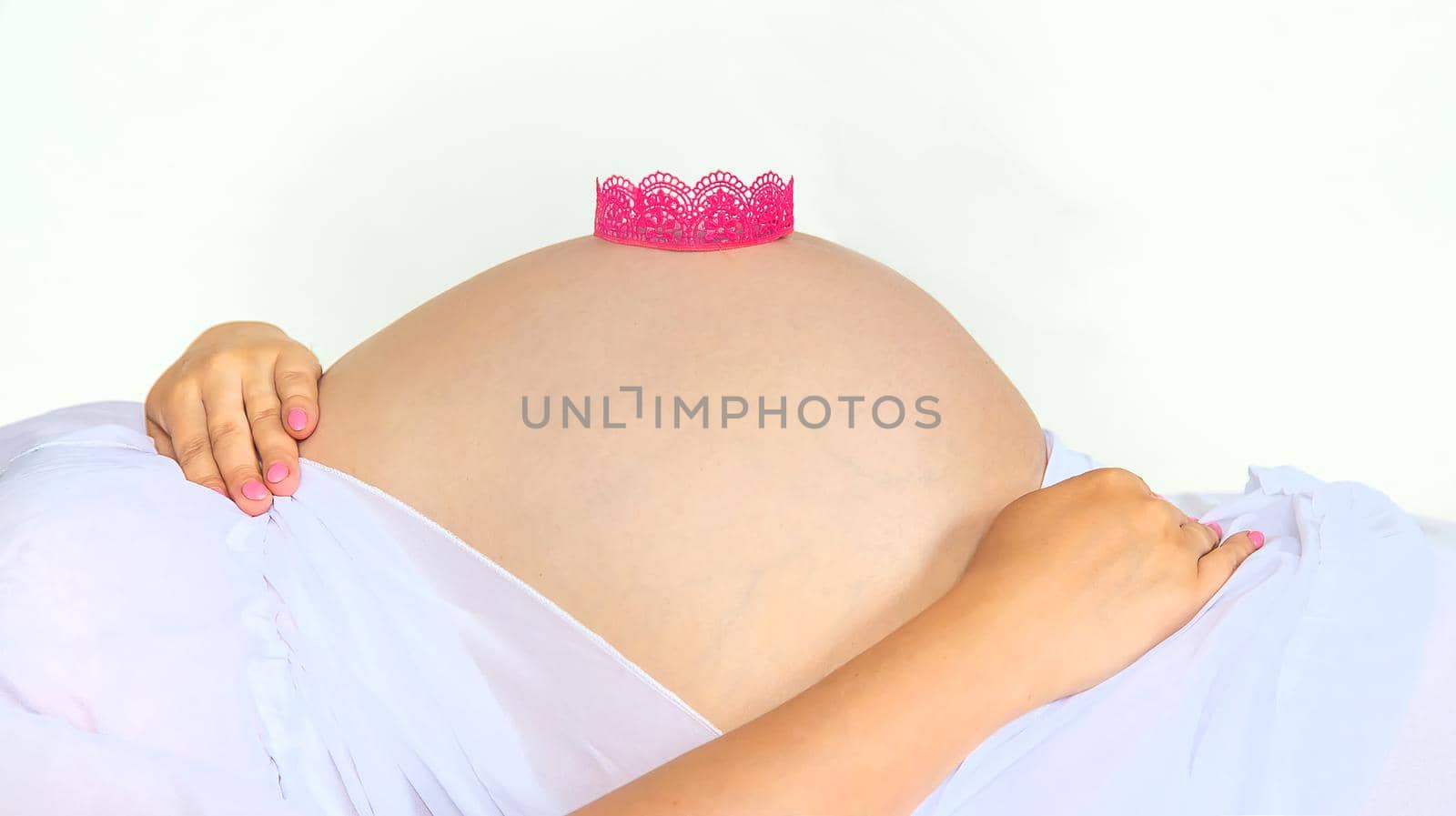 Pregnant woman crown on belly. Selective focus. by yanadjana